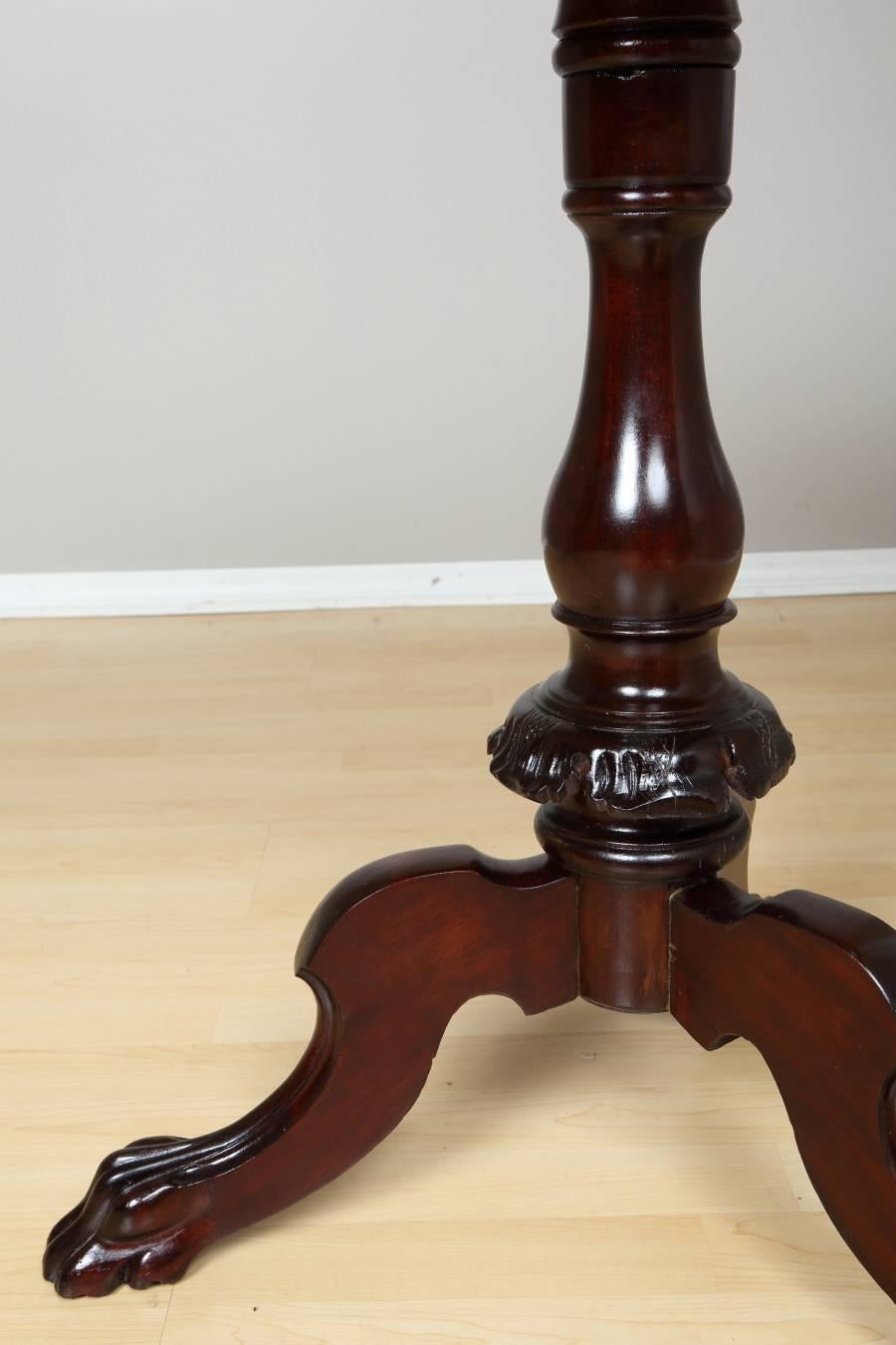 Biedermeier salon table, circa 1840. Elegant salon table from north Germany Biedermeier period. Mahogany veneer top is supported by rounded pedestal resting on lion feet - characteristic for Biedermeier period. The table has been professionally