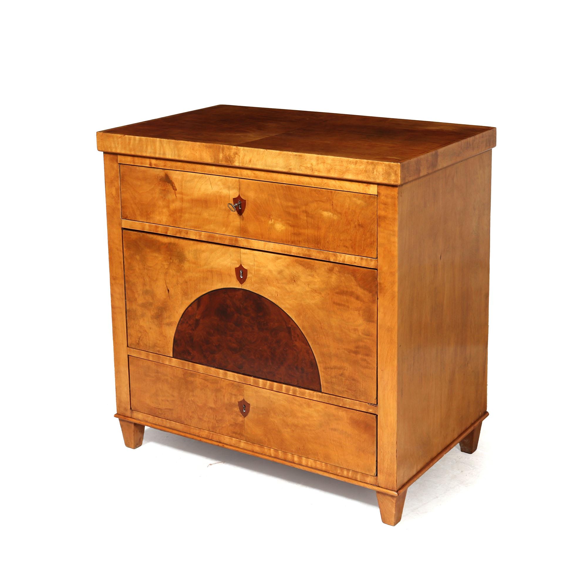 BIEDERMEIER COMMODE 
This exquisite three-drawer commode chest of drawers originates from Austria and dates back to the 1820s. Crafted from pine with a combination of satin birch and half-moon burr walnut veneer detailing, this piece exudes timeless