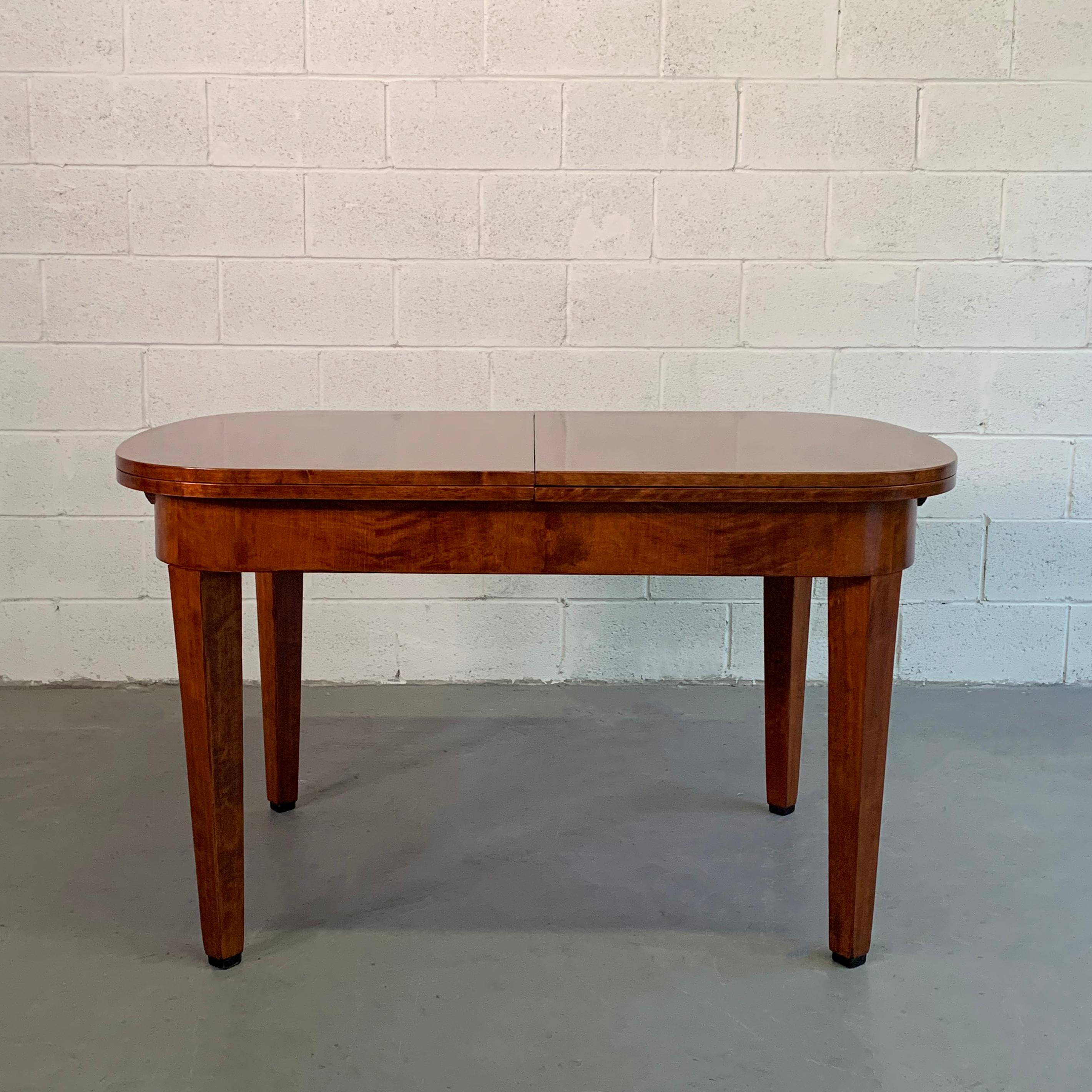 Antique, Biedermeier period, two-tone, satinwood, dining table by Ruscheweyh Tisch , Germany, features 2 leaves that tuck underneath that expand the table to 87 inches wide. The legroom height with lip is 23.25 inches.