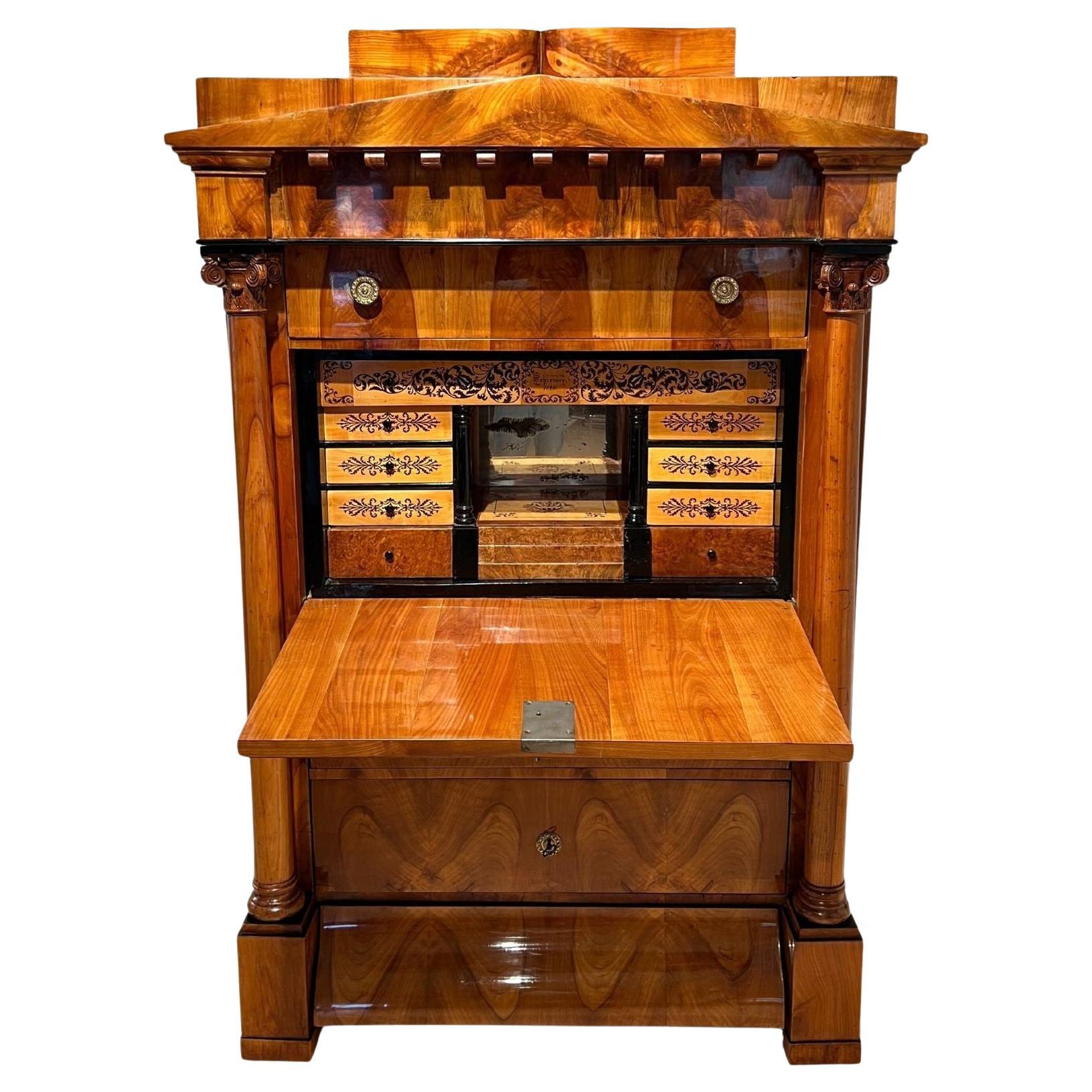 Stately large Biedermeier secretaire from south Germany around 1830.
Cherry veneered on softwood and solid cherry. Solid cherry solid columns with carved Corinthian capitals. Protruding plinth drawer ‚Karnies’ curve and butterfly veneer. Cast brass