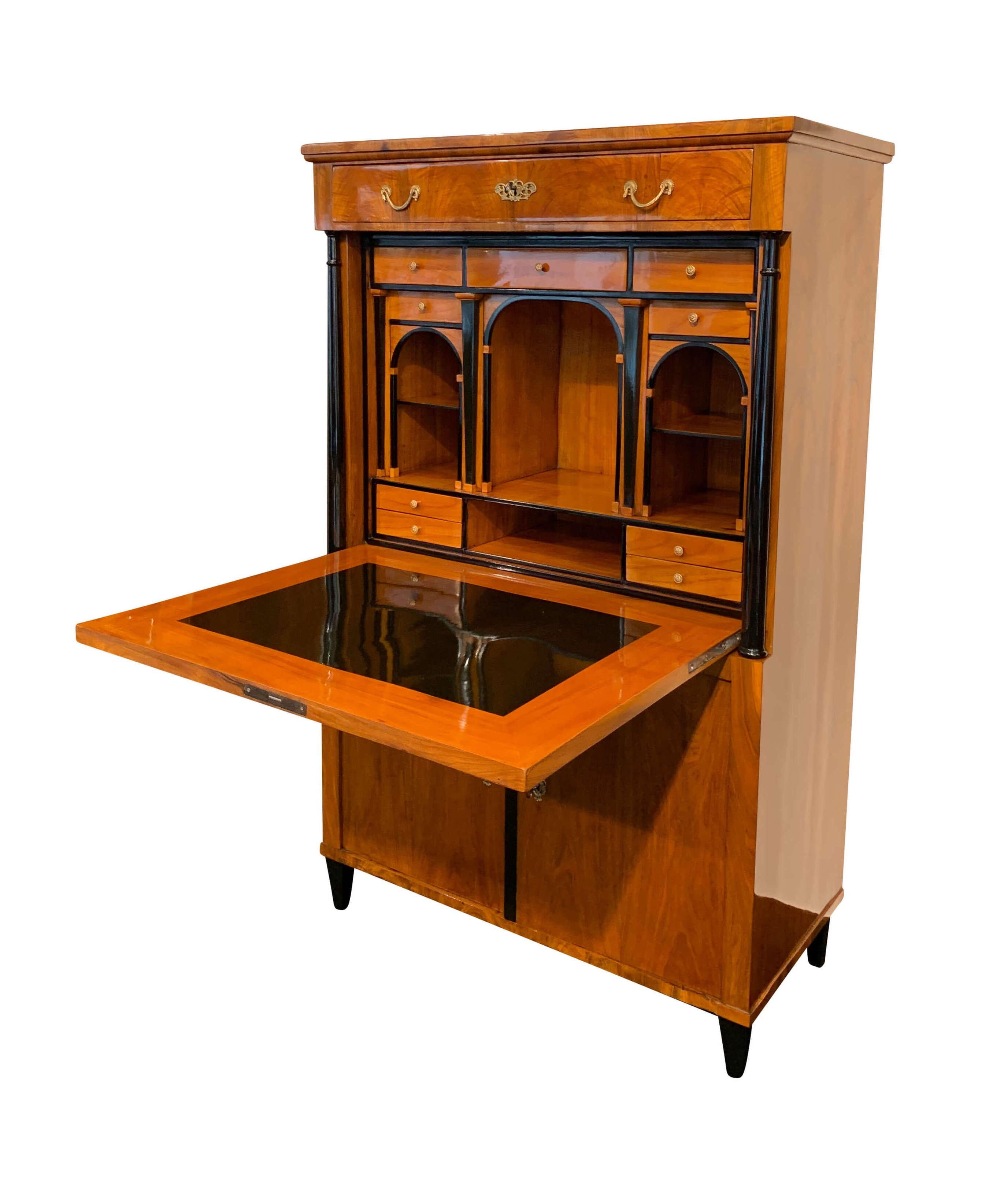 Beautiful original, neoclassical early Biedermeier Secretaire from Austria, Vienna around 1820.

Outside in book-matched walnut veneer and solid wood with ebonized conical full-columns. The fold-down plate has been done in cherry solid wood with