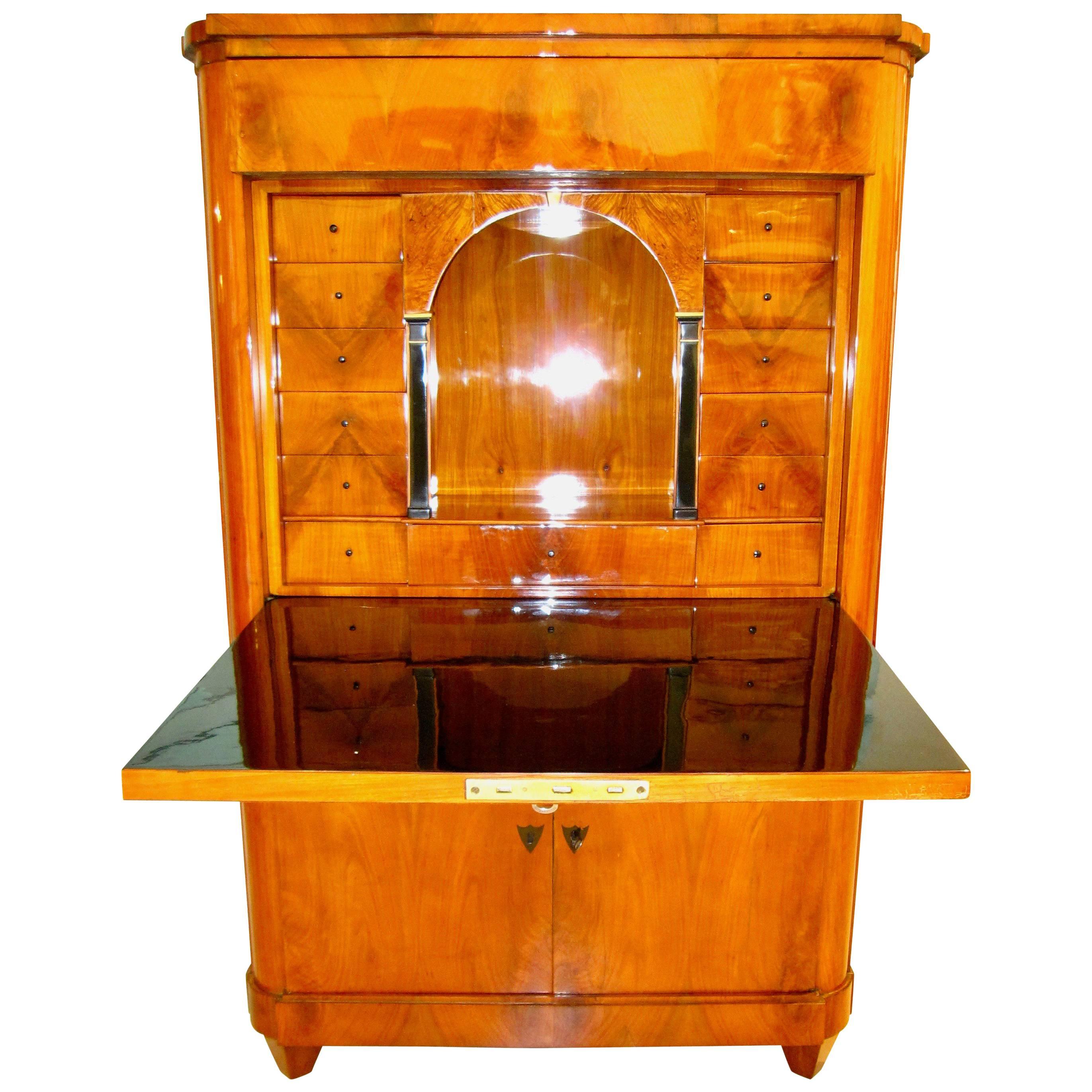 Plain and elegant early Biedermeier secretary with a wonderful book-matched cherry veneer. The drop-down door has a blackened surface inside for writing. Dropped-down it has a depth of 97 cm /32.2