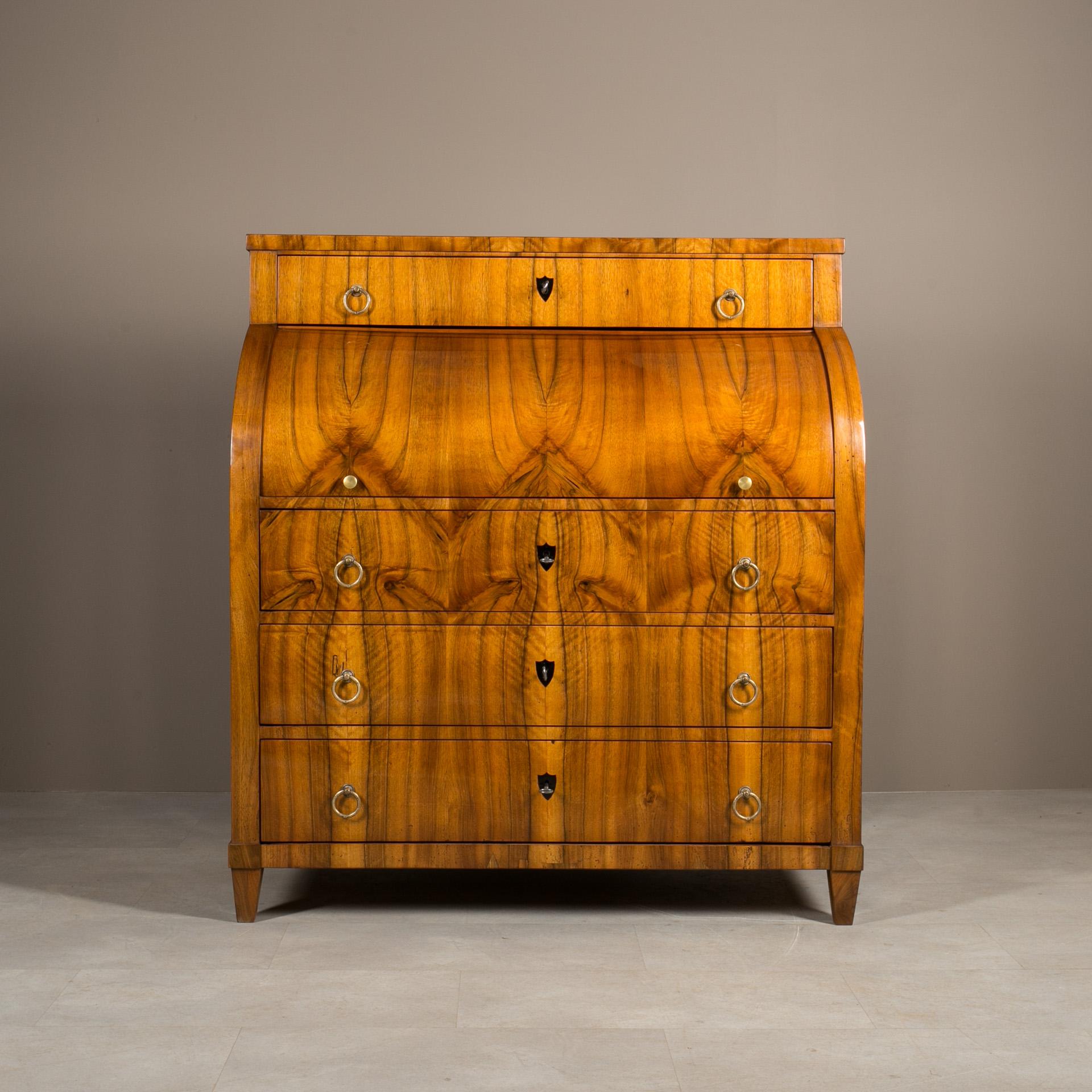 Eleva tu espacio de trabajo con este impresionante escritorio de secretaria, una extraordinaria pieza de mobiliario procedente de Alemania, fabricada en la primera mitad del siglo XIX. Fabricado en madera de pino y elegantemente chapado en