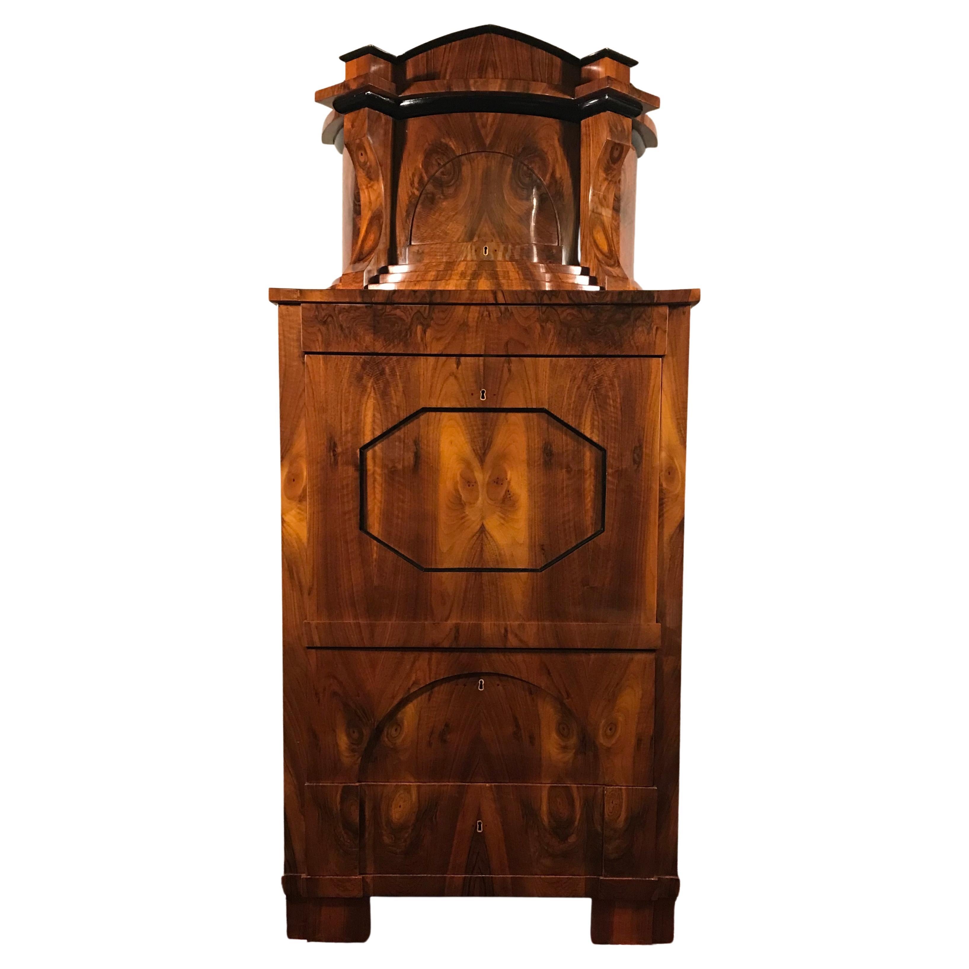 This extraordinary Biedermeier secretary desk dates back to around 1820 and comes from southern Germany. The unique desk has a very pretty walnut veneer on the outside, with a beautifully designed mirroring veneer pattern. The secretary desk has