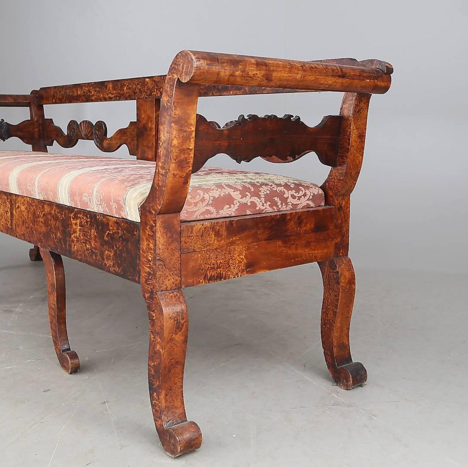 Precioso e insólito sofá Biedermeier antiguo sueco del siglo XIX, de abedul dorado acolchado de primera calidad, con un profundo acabado pulido a la francesa y preciosos detalles tallados.

Tiene delicadas patas, respaldo tallado y motivos de concha