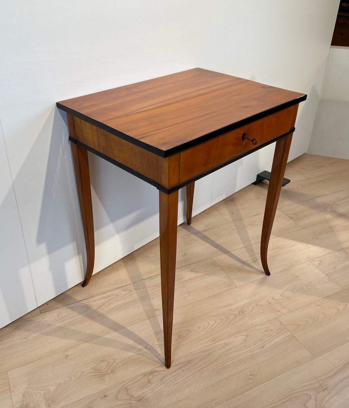 Beautiful original Biedermeier sewing or side table in cherry wood from South Germany around 1825.
Cherry wood veneered and solid. Drawer with original sewing equipment.
Elegant, curved square tapered legs. Restored and hand polished with