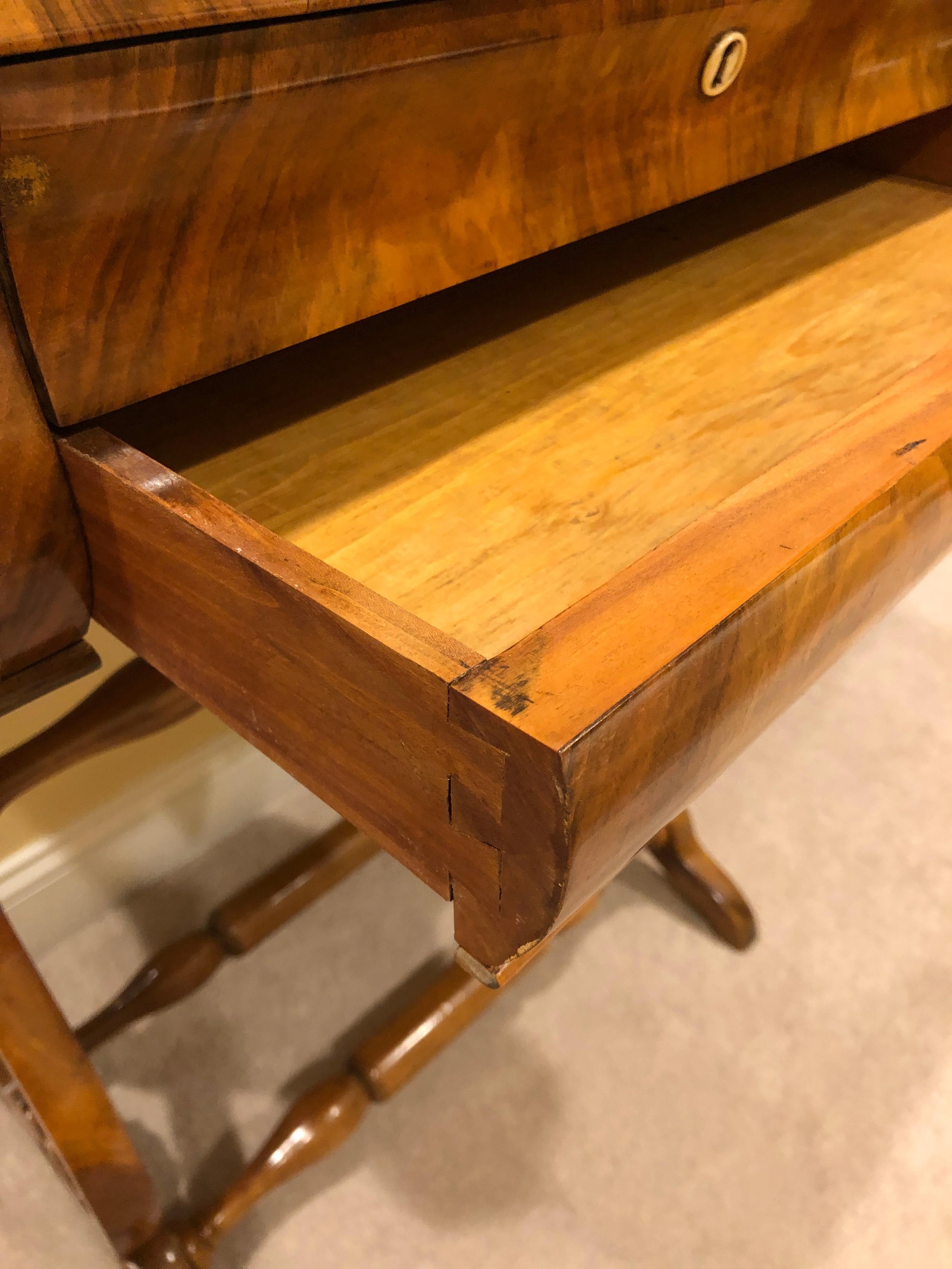 Original Biedermeier sewing table, South German 1820, walnut veneer. Beautiful table with exquisite veneer grain on the top. Two drawers, the upper one with small compartments and a pincushion. The table is in good condition and has a nice patina.