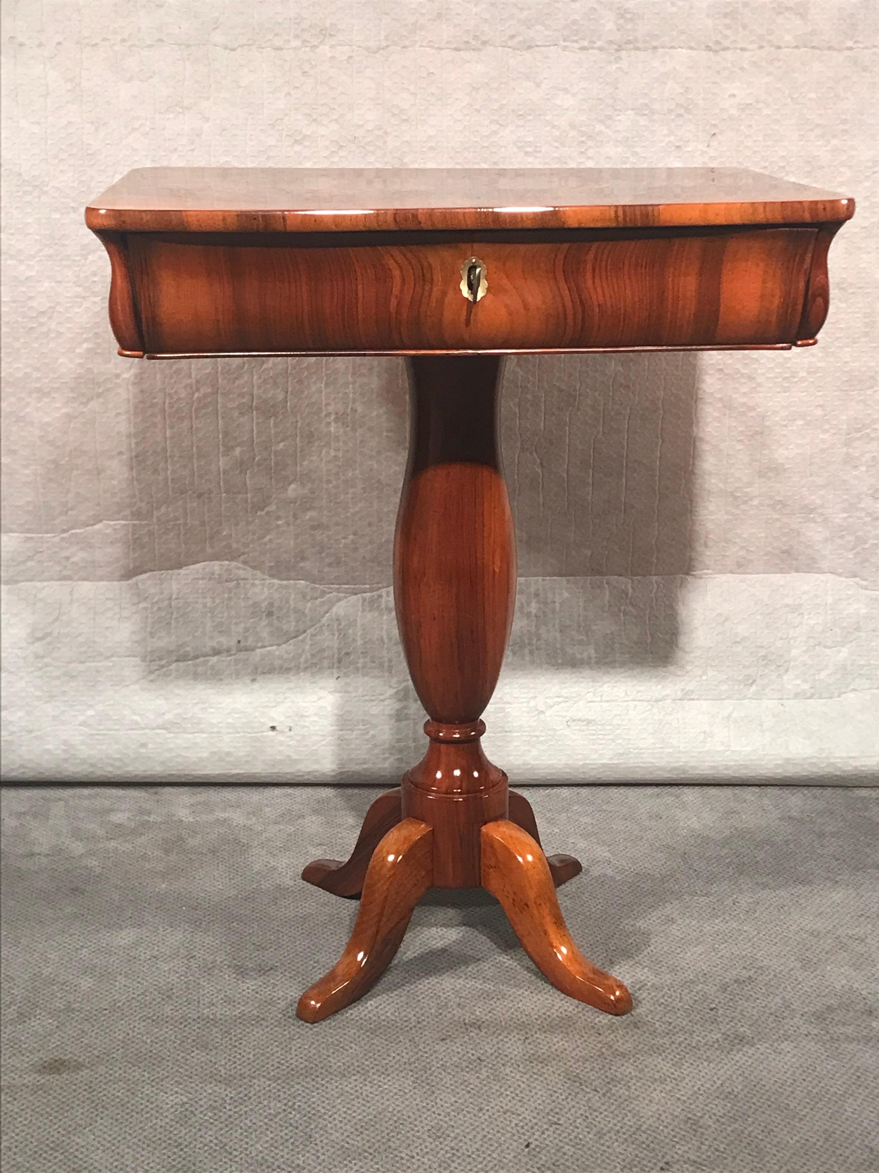 Dieser einzigartige Biedermeier-Nähtisch kommt aus Süddeutschland und stammt aus dem Jahr 1830. Der Tisch steht auf einem zentralen Fuß und hat eine Schublade. Die Platte zeichnet sich durch ein sehr schönes Walnussfurnier aus. Es kommt in sehr