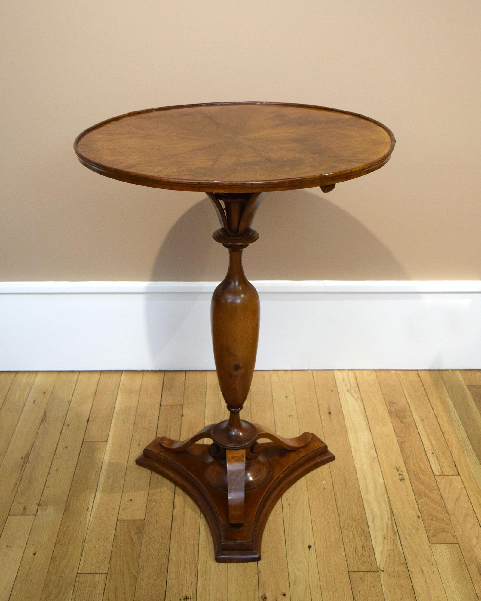 Elegance and charm tend to be mutually exclusive, but the best Biedermeier furniture often embodies both. Our side table was finely made of solid and veneered walnut. By sliding a bronze latch, the top tilts vertically. This is a common enough