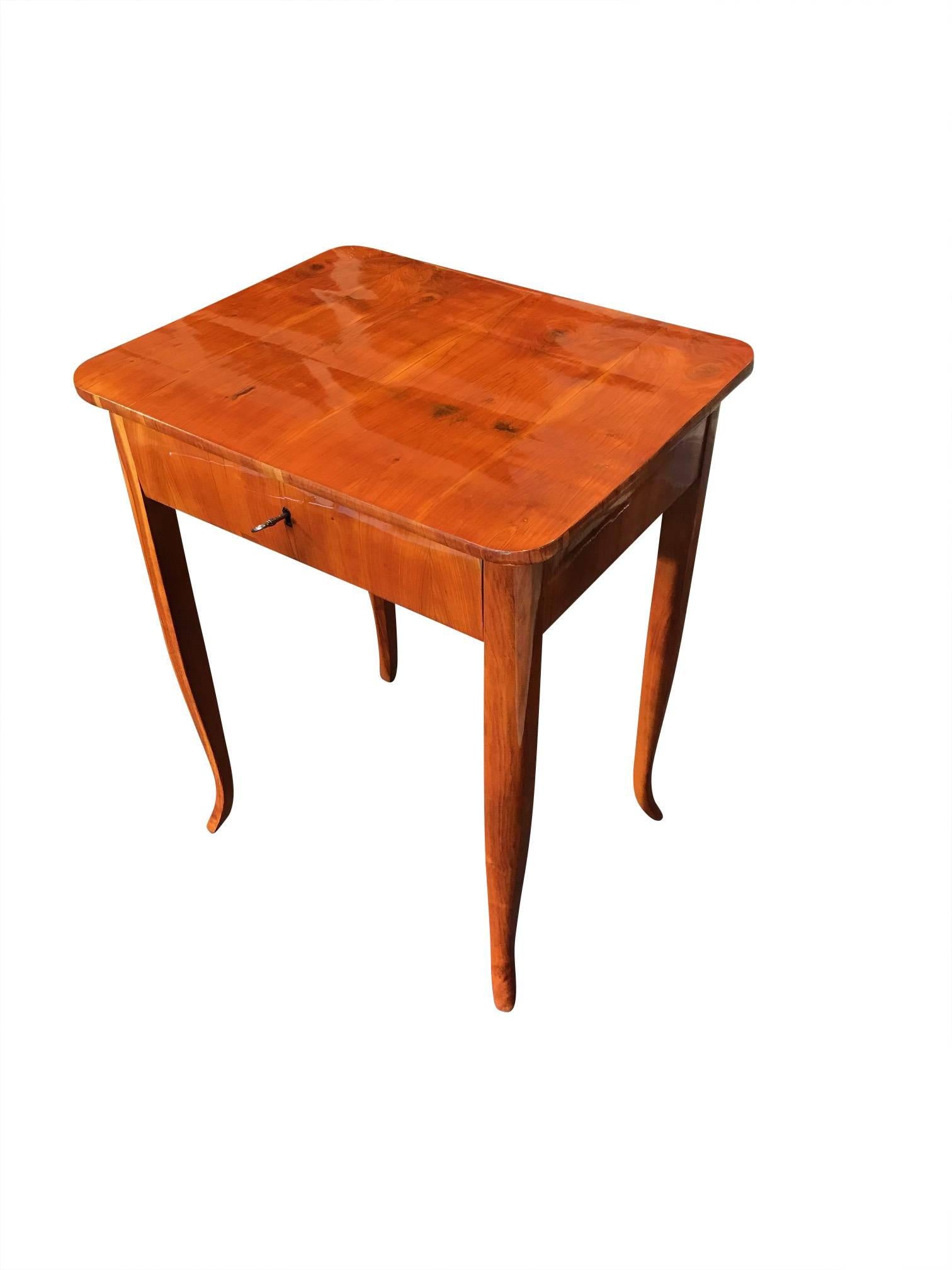 Wonderful and very elegant Biedermeier side table from South Germany, manufactured circa 1830. The table has one drawer at the front, is veneered with cheerywood and also has cherry solid wood parts like the curved legs. The key sign is ebonized and