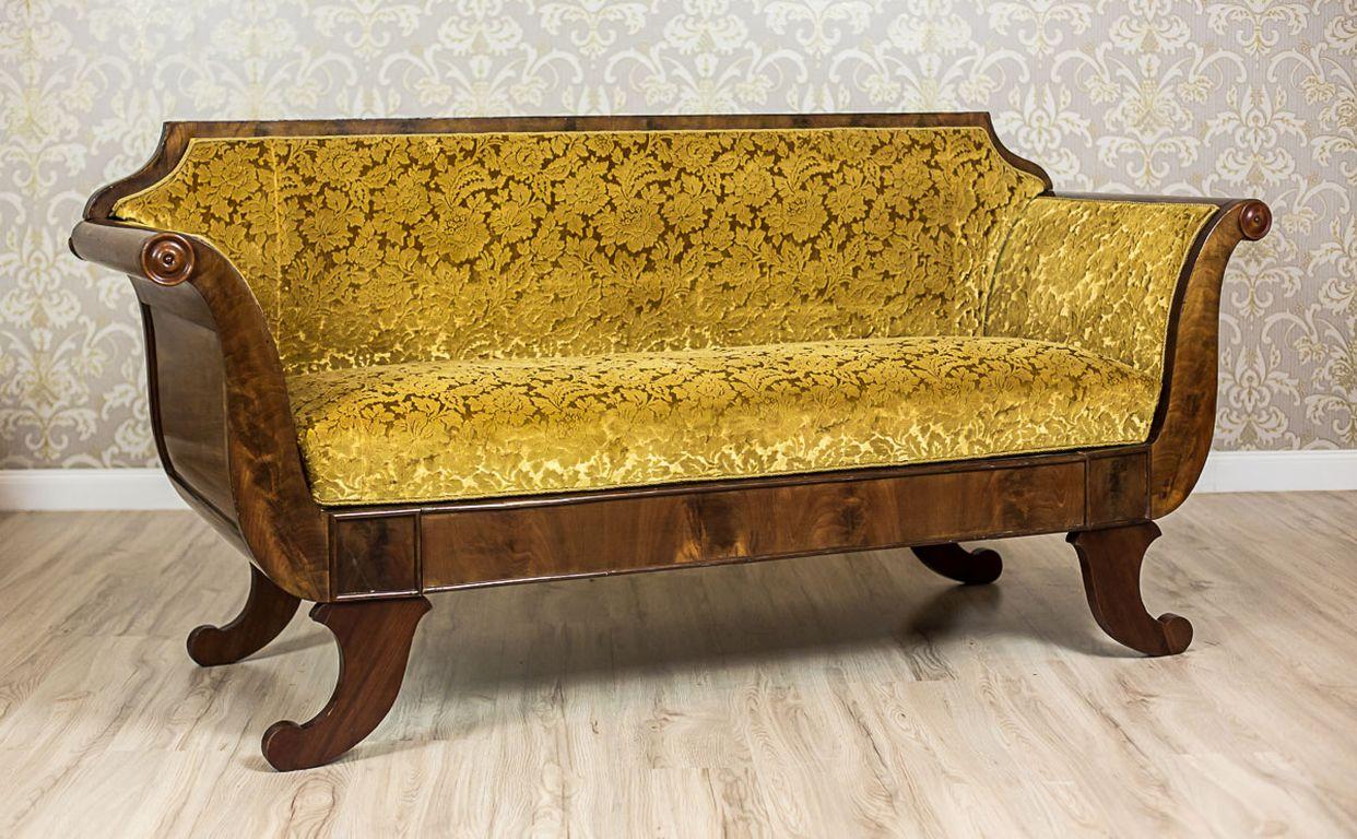 We present you this sofa of a classic shape, which is characteristic for the style.
The wooden corpus is covered with mahogany veneer.
The legs end with volutes. Moreover, the armrests are characteristically rolled outwards.
Also, the inside of