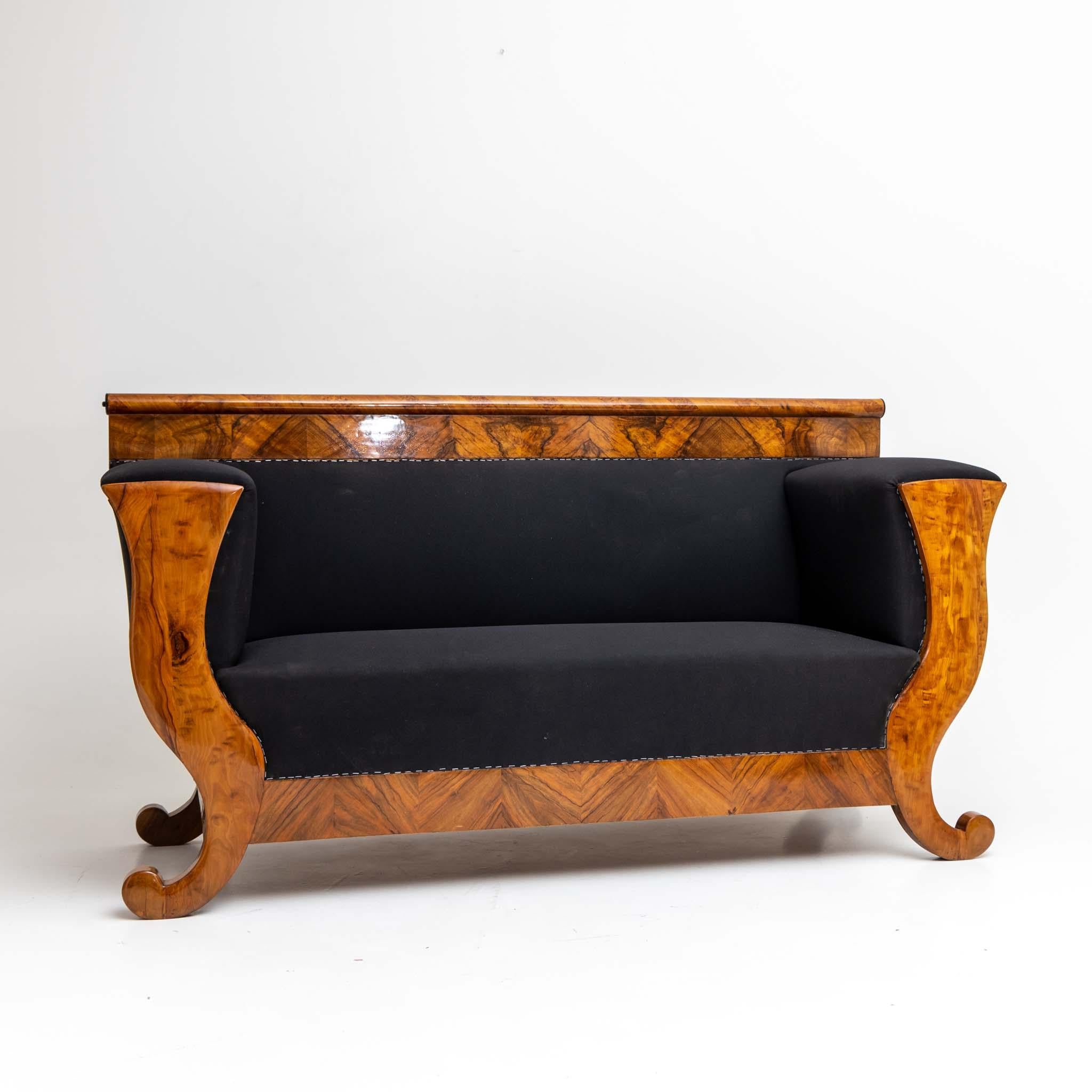 Large Biedermeier sofa with thick armrests and curved sides. The sofa is veneered in walnut and has been polished by hand. The Sofa has been reupholstered with a black base fabric and is ready to be covered with a new outer fabric. Old label on the