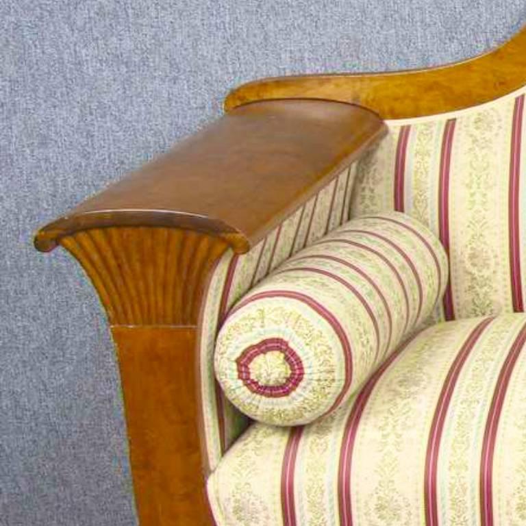 Antikes schwedisches Biedermeier-Sofa mit geschnitztem Dreiviertelsitz in klassischem, dunklerem Honig-Französisch-Finish, das die Figur in den hochwertigen, gesteppten Birkenfurnieren hervorhebt.

Die Armlehnen sind mit Fächermotiven versehen,