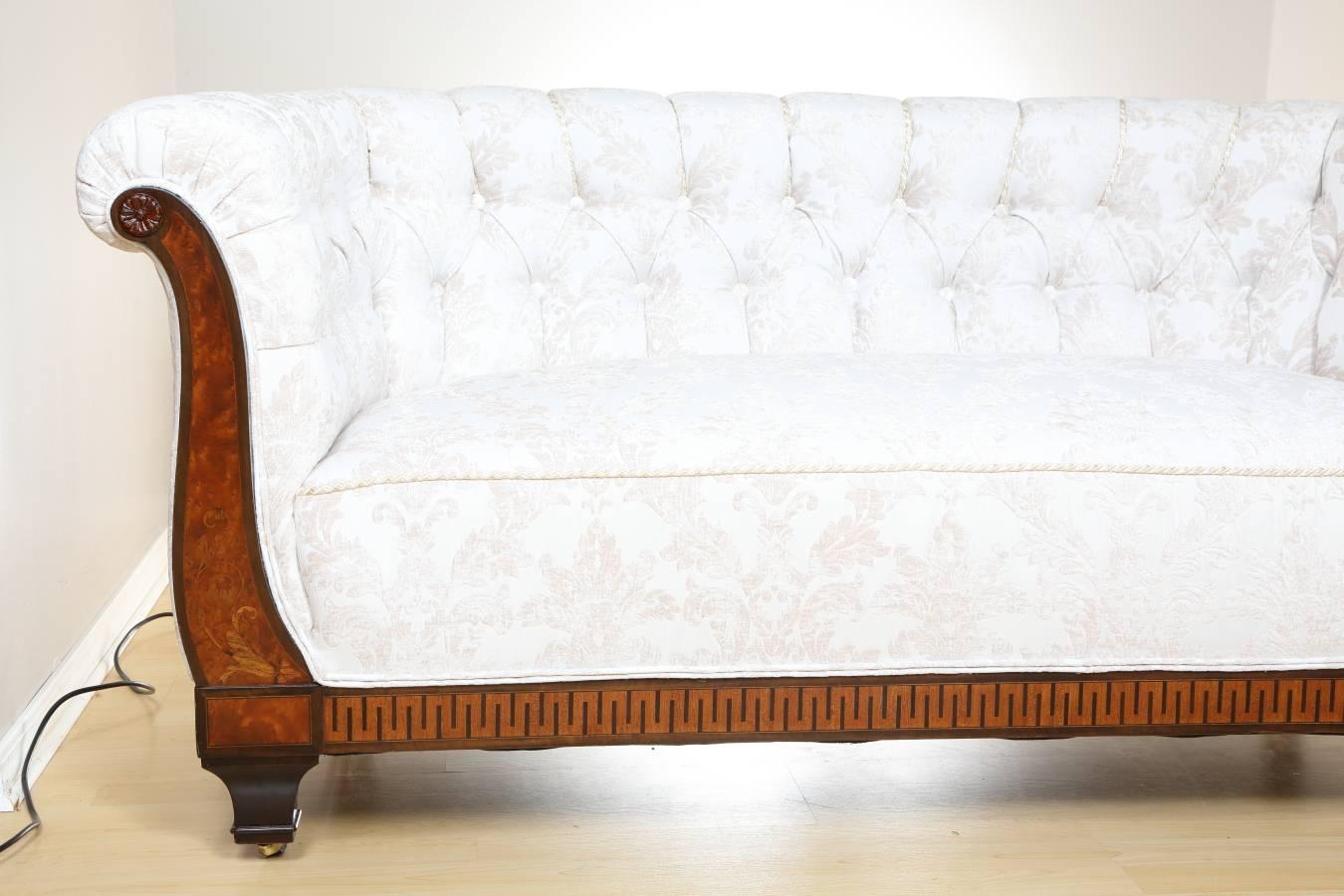 Biedermeier sofa, circa 1810 from Germany. Elegant, comfortable, fully upholstered Biedermeier sofa with spring seat and tufted back. At the front, the sofa features elegant inlays of walnut, birch, mahogany, and black oak. It has been restored