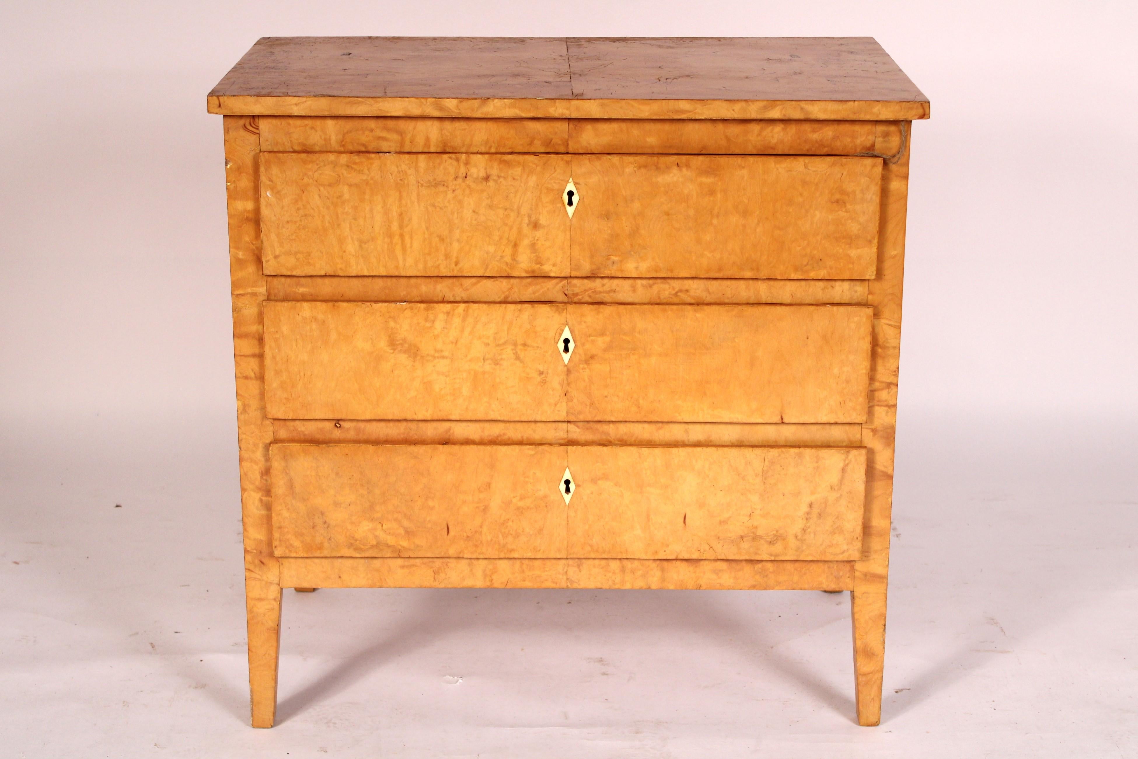 Biedermeier style birch chest of drawers, circa 1960's. With a rectangular top, 3 drawers with diamond shaped bone escutcheons, resting on square tapered legs. This chest would be at home in either a contemporary or neo classical style interior.