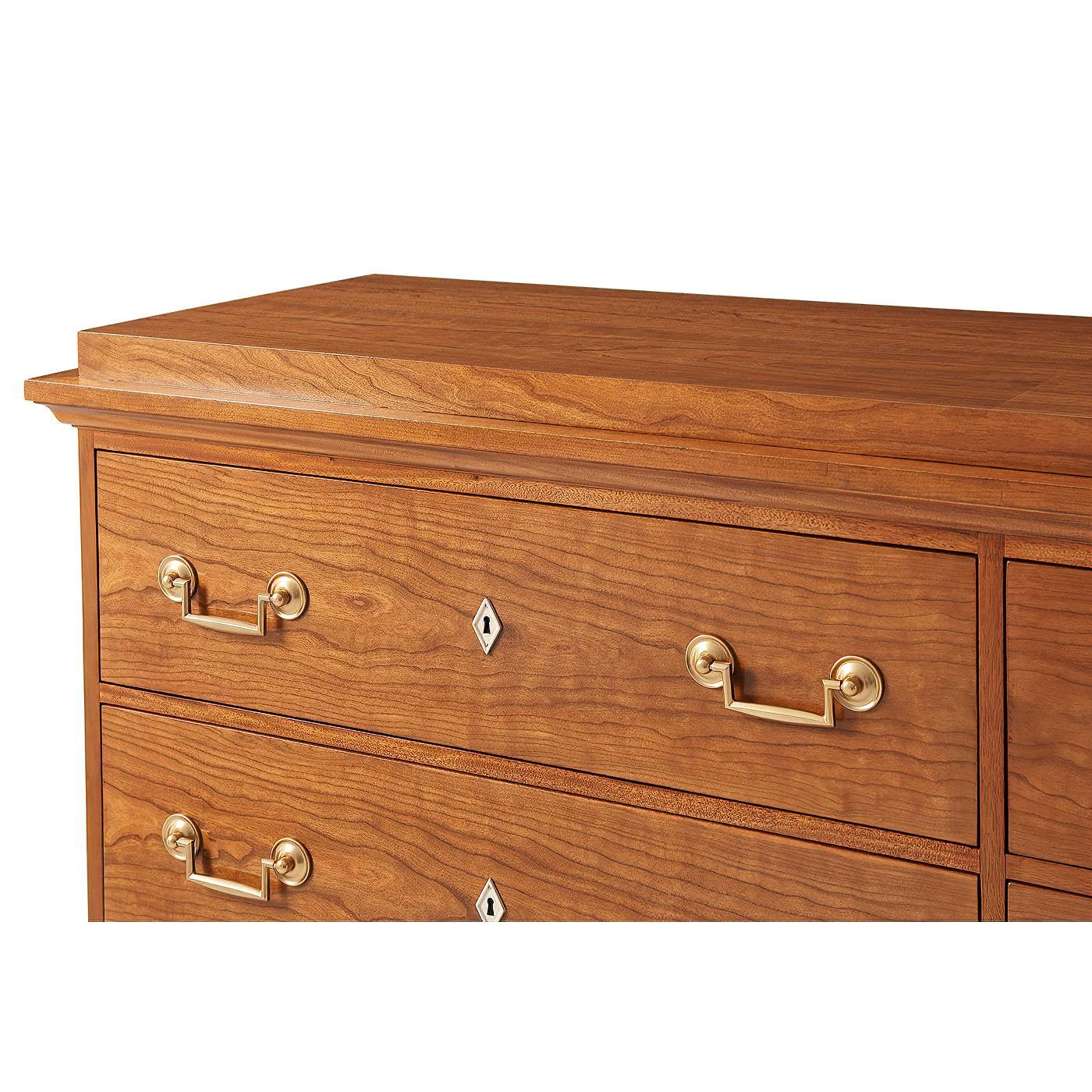 A Biedermeier dresser, architectural detailing shines in the six-drawer long dresser fitted with brass handles and ivory-finish escutcheons. Beautiful stepped-caddy dresser top and bracket feet. Solid cherry and veneers and soft-closing drawer