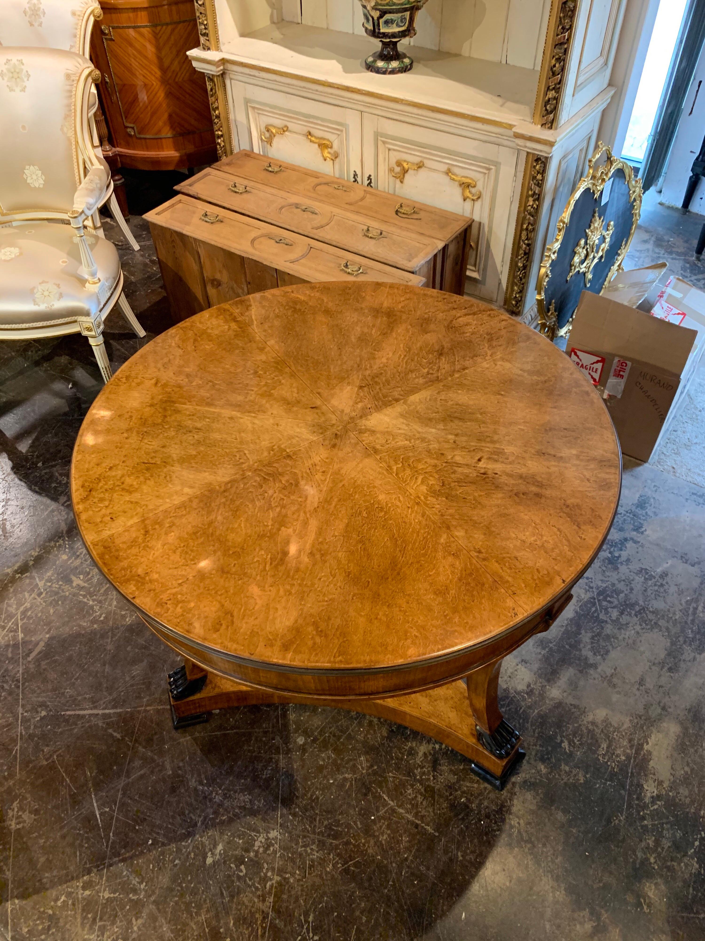 Very handsome Biedermeier style center table with ebonized claw feet. Beautiful finish on this piece and there is also brass along the top edge of the table. An absolute gorgeous table that creates a lovely polished look!