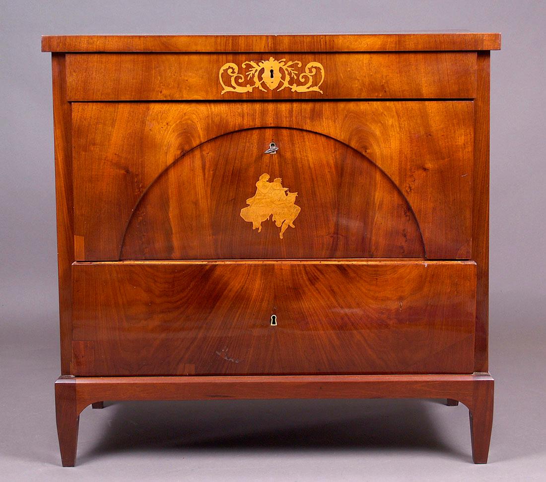 Biedermeier style pine chest of drawers with a writing desk, circa 1830

Rectangular, three drawers, the top of which, when open, serves as a writing table. It is supported on four angular converging legs, decorated on the front of the central
