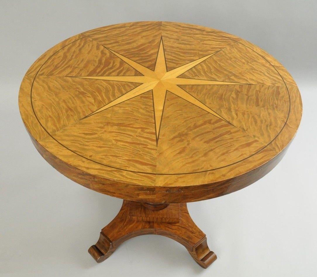 Biedermeier style round pedestal base center table. Item features round top with inlaid star and burl wood veneer, pedestal base with black pineapple central column, four curved feet, Classic and elegant Biedermeier form, circa late 20th century.