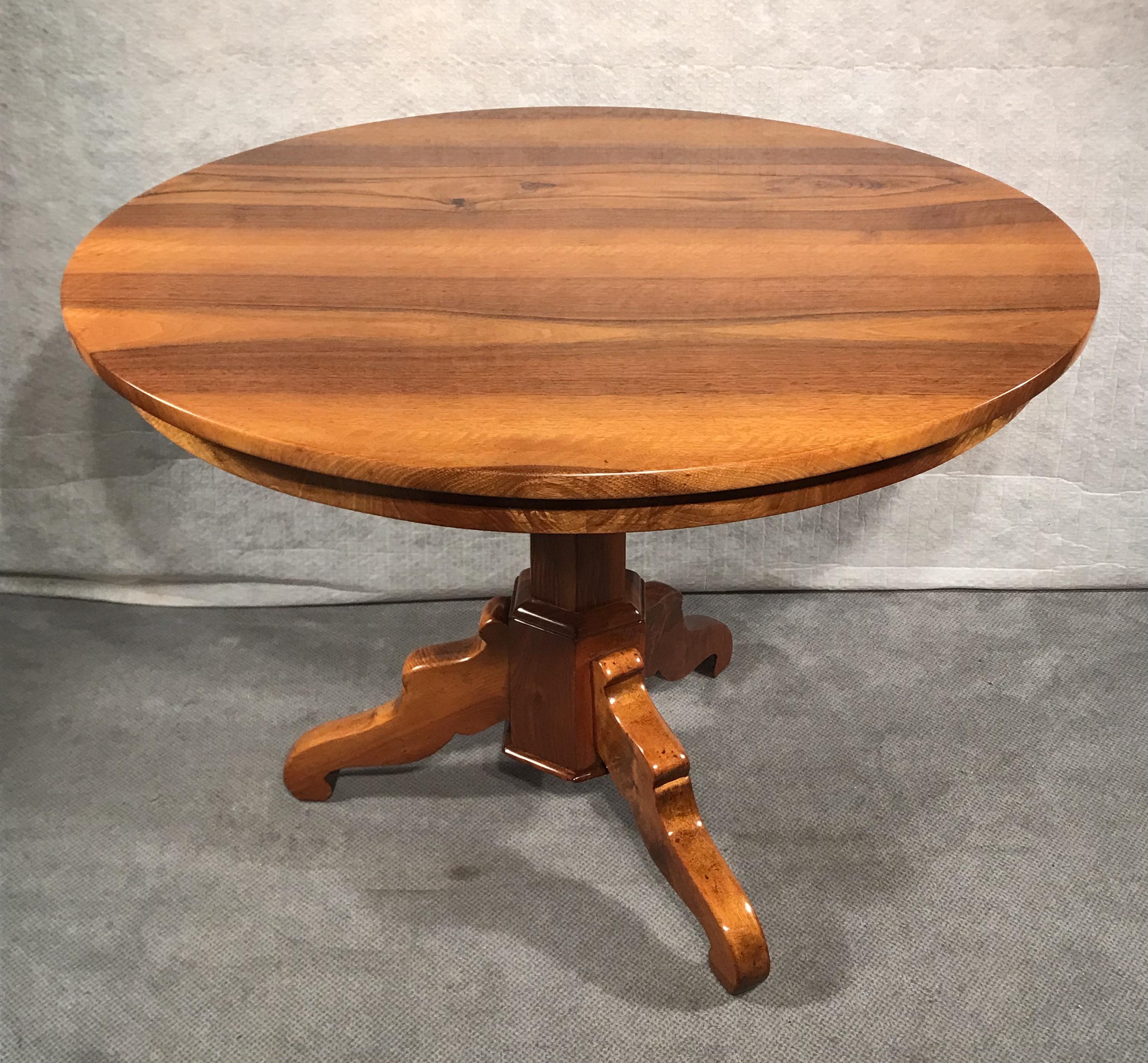 This original Biedermeier table dates back to around 1830. It comes from Southern Germany. The table stands on a hexagonal column which rest on a trefoil base. 
Top and base have a pretty walnut veneer. The table comes refinished with a shellac