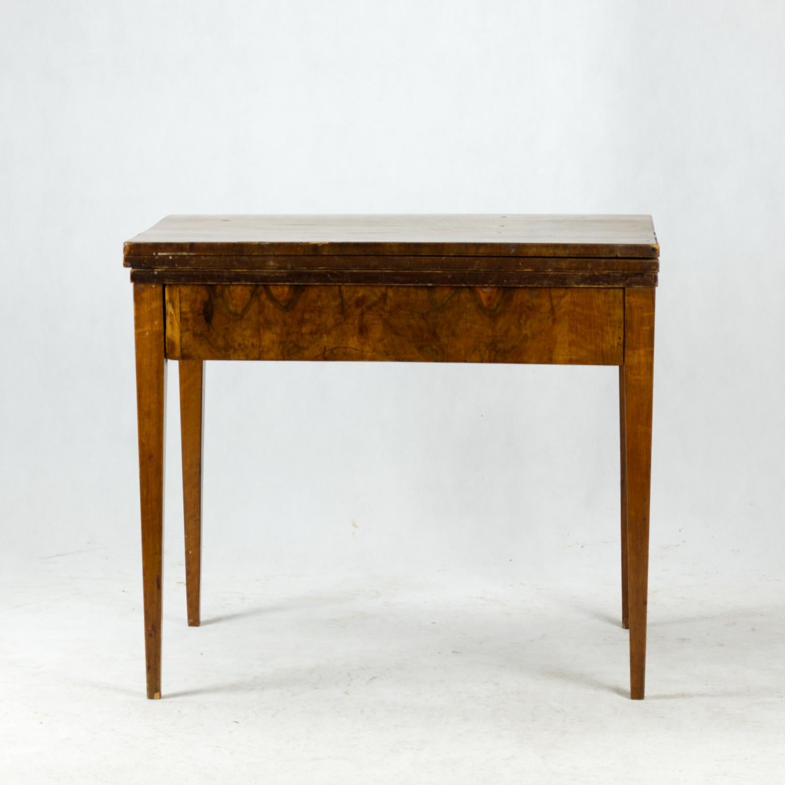 Cette table date de la période Biedermeier, au début du XIXe siècle. Le corps de la table est en bois d'épicéa et a été recouvert d'un très beau placage épais en noyer. La table est en bon état. La taille de la table déployée est de 81 x 119 cm.