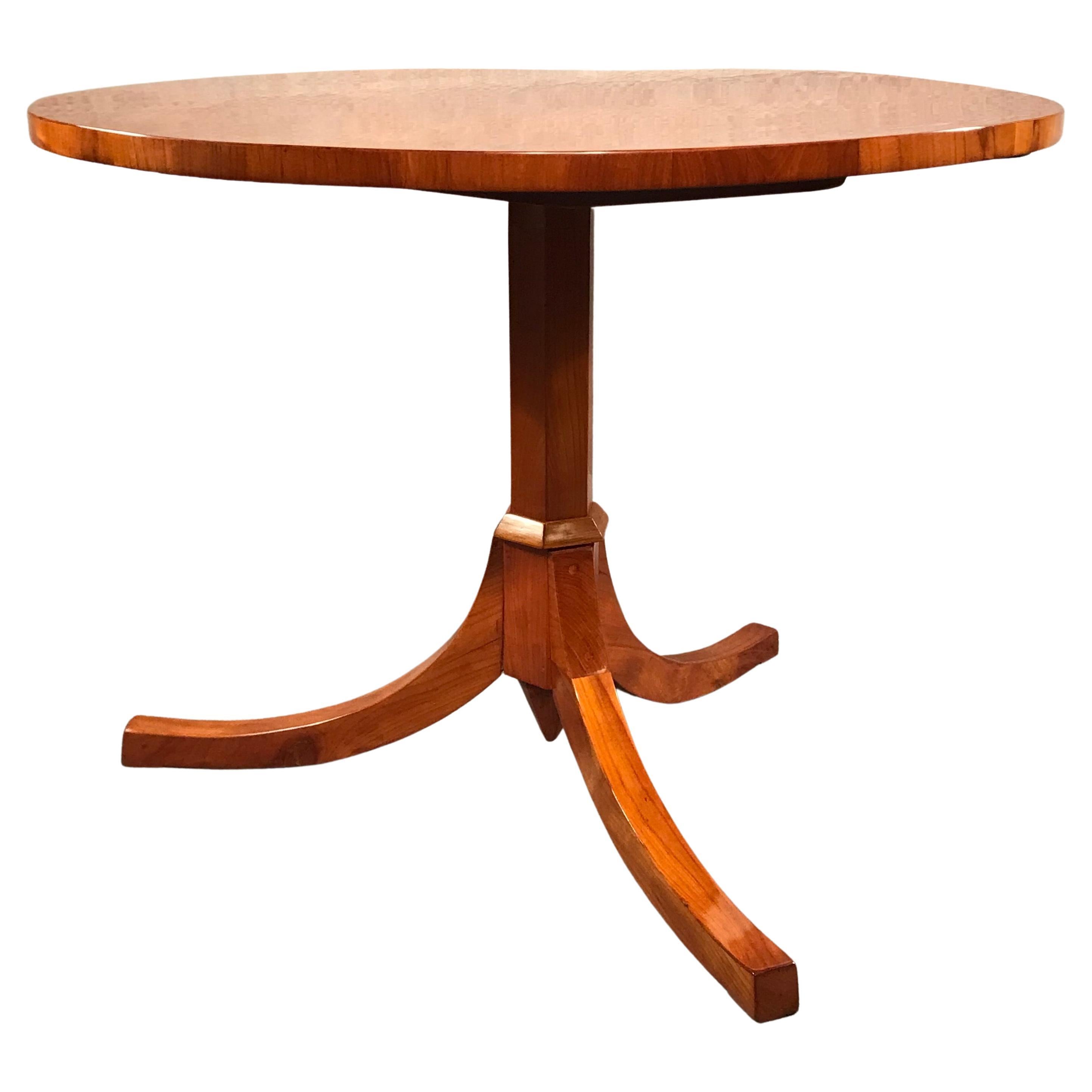 This original Biedermeier table dates back to around 1820-30 and comes from southern Germany. The table stands on a hexagonal column which rest on a trefoil base. The antique Biedermeier table has a pretty European cherry veneer on top and base. It