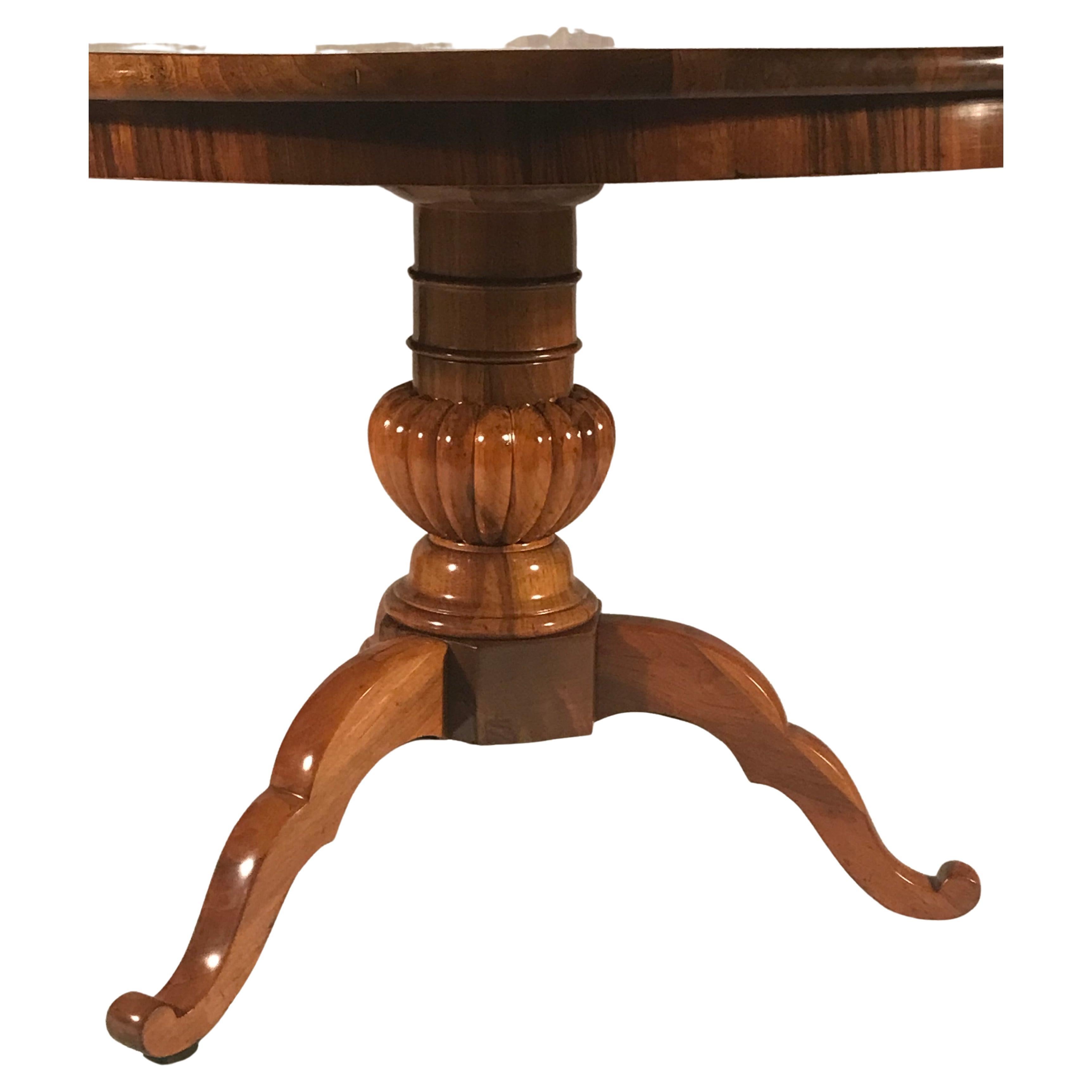This unique Biedermeier table is truly a masterpiece. Its standout feature is the central column base, elegantly supported by a tripod foot. The craftsmanship and attention to detail are evident in every aspect of this table.

The top of the table