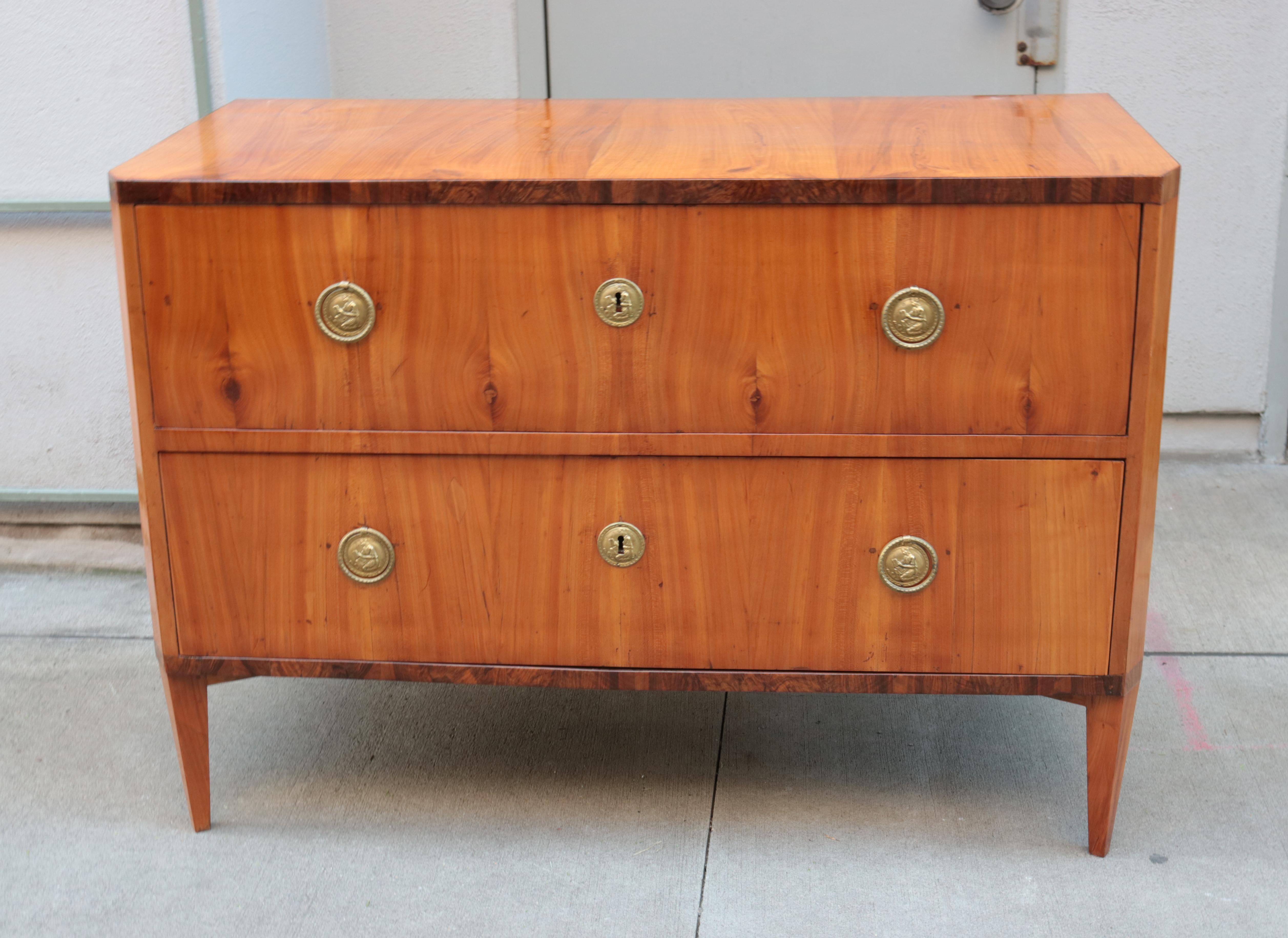 Biedermeier two-drawer commode.
Walnut with patinated brass details.