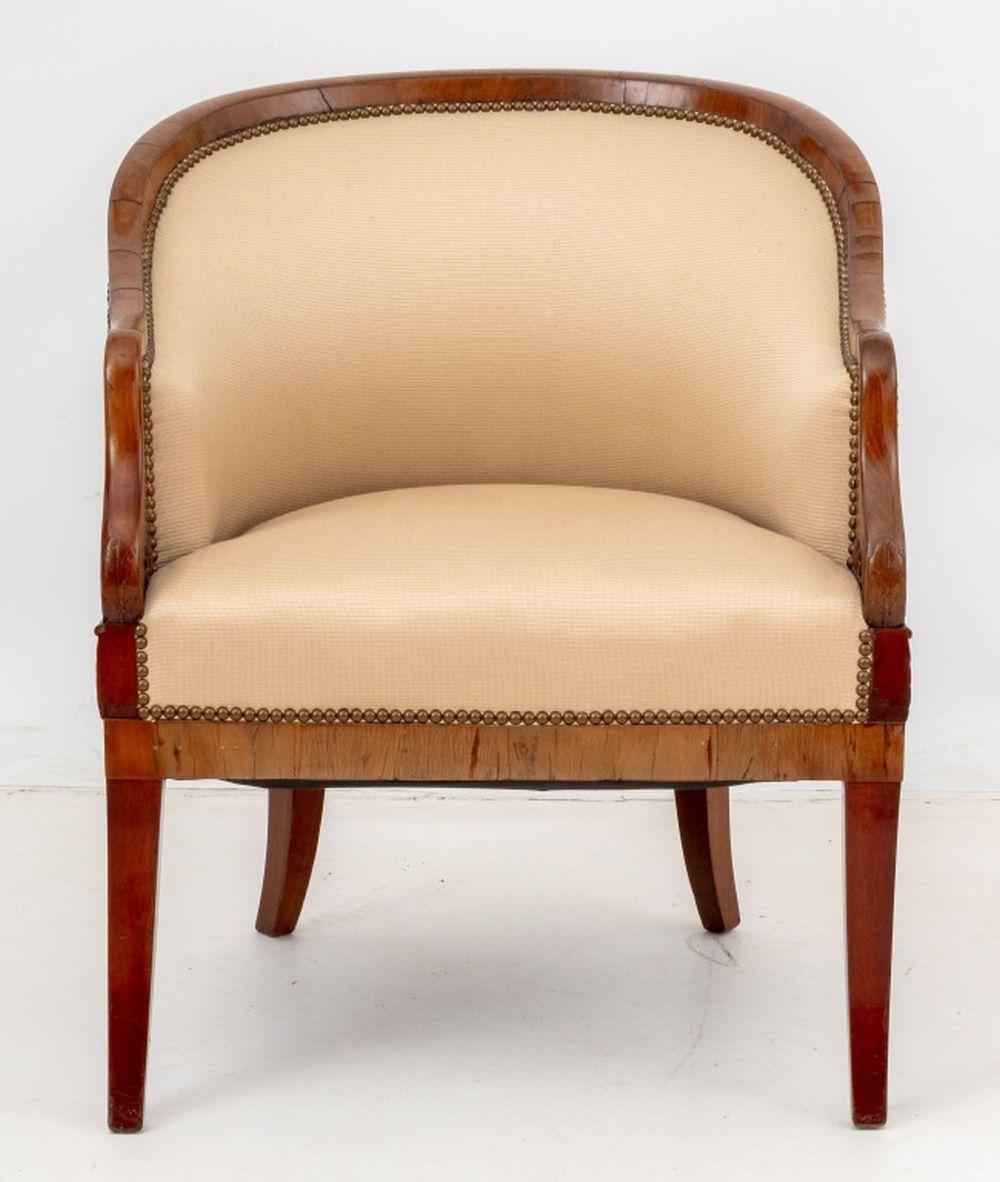 Chaise à baignoire en bois fruitier tapissée Biedermeier, première moitié du 19e siècle, sculptée d'un motif de feuillage sur les accoudoirs et recouverte d'une tapisserie beige personnalisée avec des détails de têtes de clous. 34.25