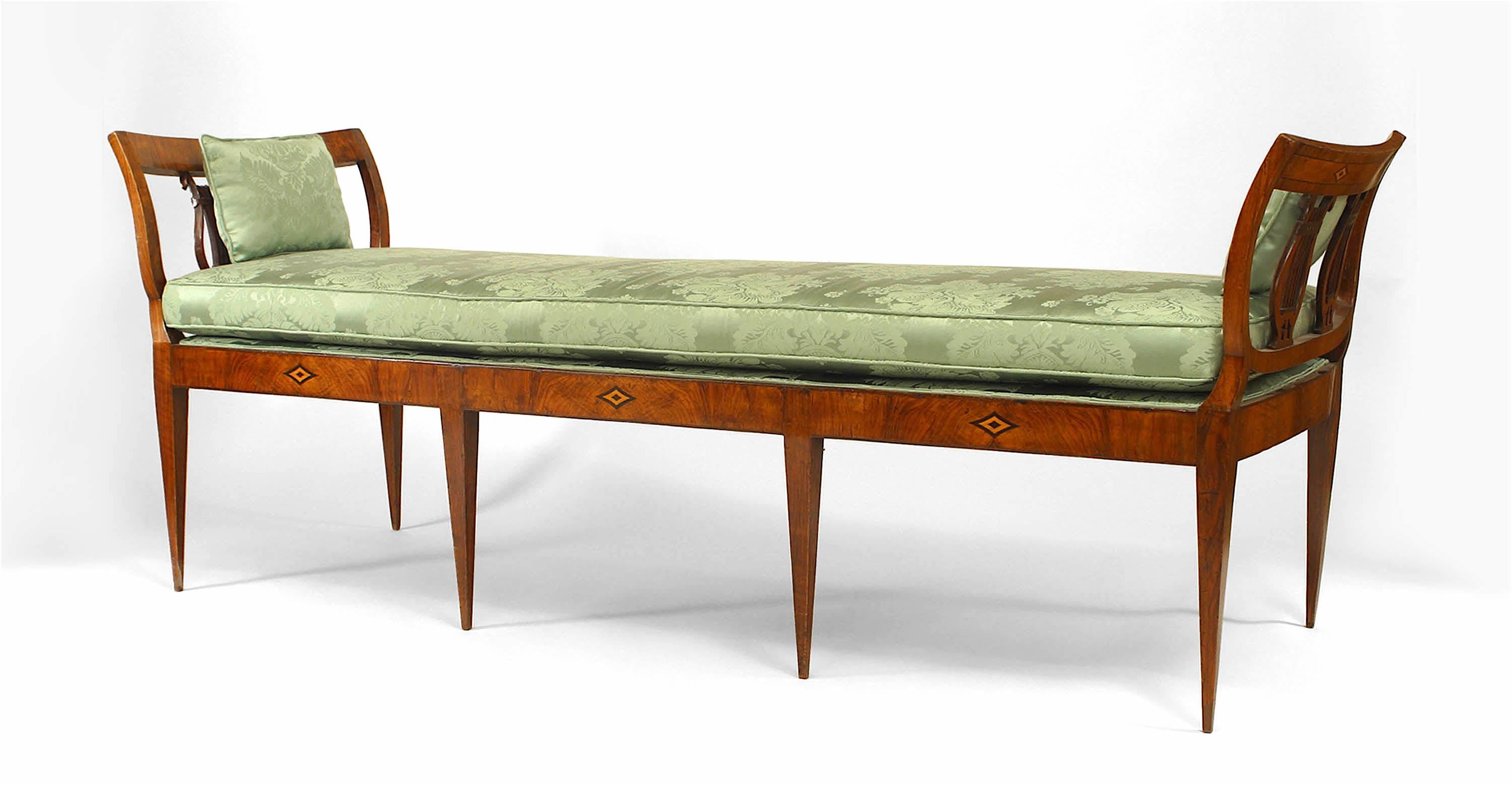 German Biedermeier walnut bench / daybed on tapered legs with open double lyre side arms and marquetry diamond design inlay with green upholstered seat cushion.
