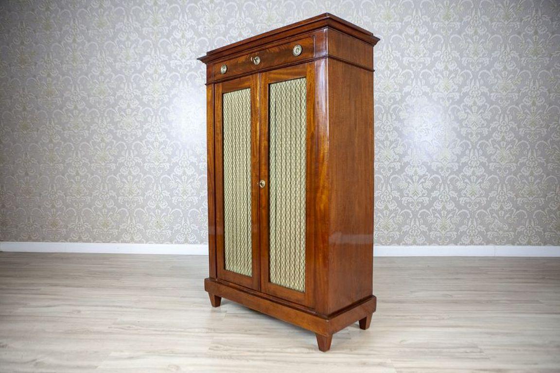 Vertico Softwood and Walnut Venner in the Biedermeier Style Circa 1850

Furniture in the form of a vertical cabinet with a simple, austere design. A two-door body with a top drawer is set on a slightly protruding, straight plinth, crowned by a