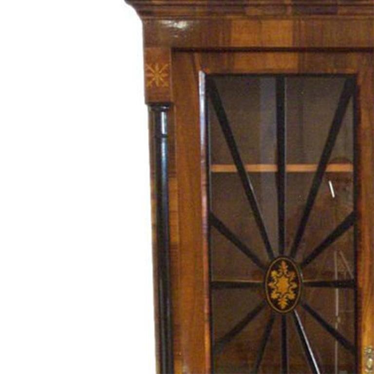 Biedermeier Vitrine/Bookcase – walnut, rootwood and ebonized wood and columns with brass hardware.  Glazed doors with ebonized columns in spindle pattern and interior shelves.