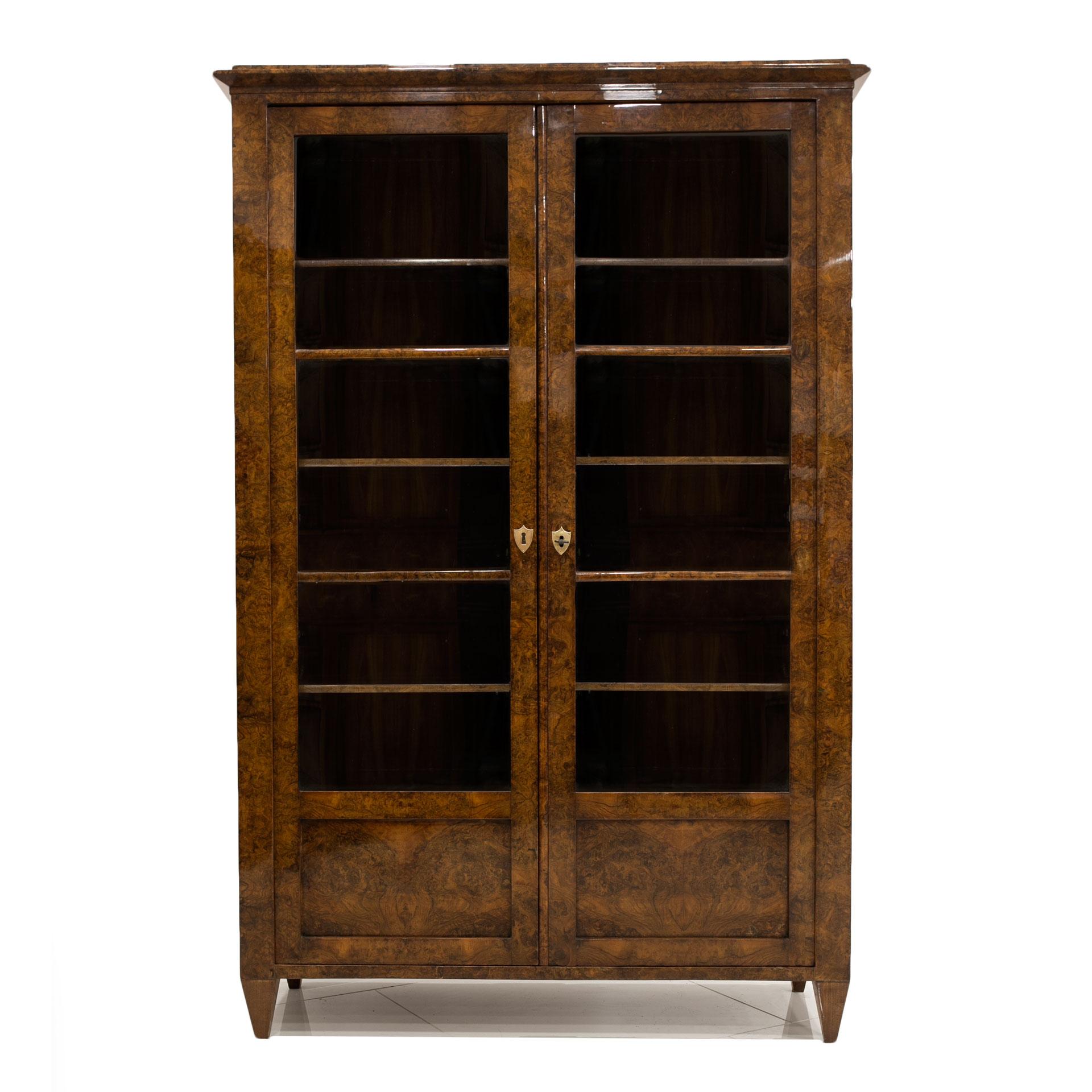 This Biedermeier vitrine comes from Germany and was made, circa 1830-1850. It is made of coniferous wood, veneered with burled walnut with a very decorative drawing. It has undergone a professional renovation process. The surface is finished with