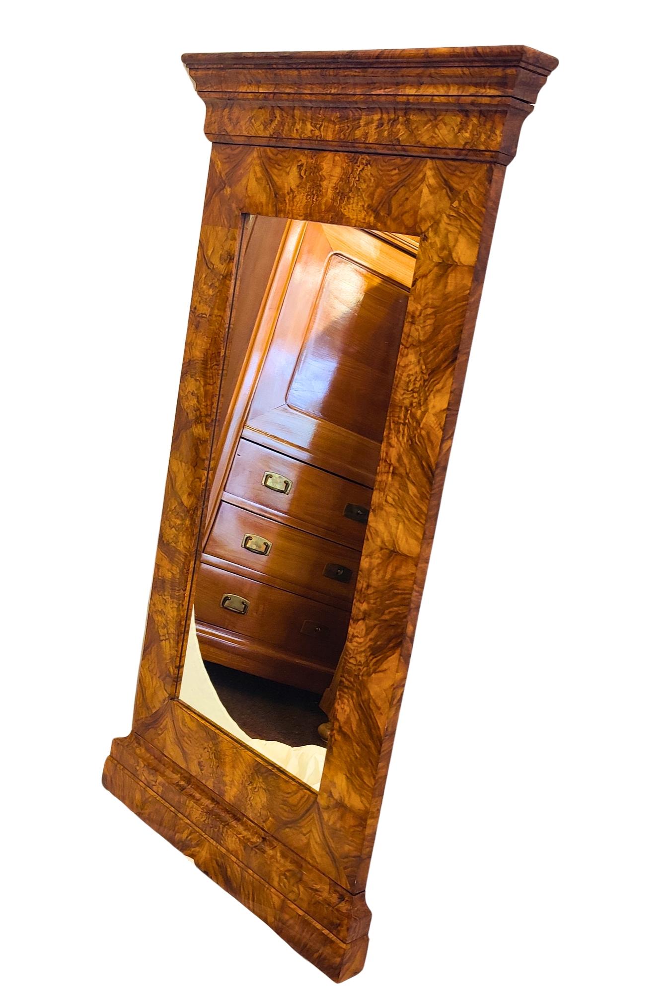 Questo squisito specchio Biedermeier risale al 1830 circa e proviene dalla Germania meridionale. La struttura è realizzata con un'impiallacciatura di noce splendidamente granulata su un'anima di legno dolce e presenta le linee architettoniche pulite