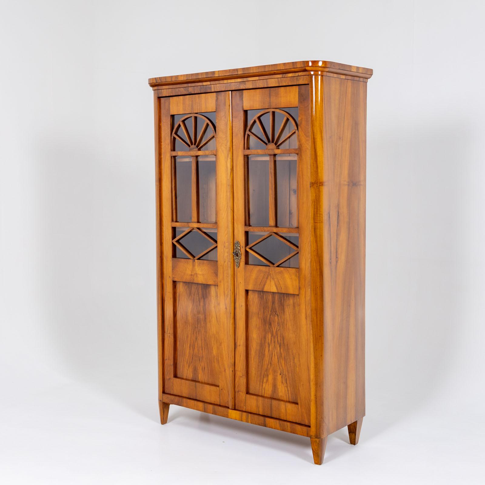 Two-door bookcase with half-glazed doors and beautiful molding with segments and diamond decoration. The interior of the bookcase is fitted with height-adjustable shelves. The cabinet is veneered in walnut and has been restored and polished by hand. 