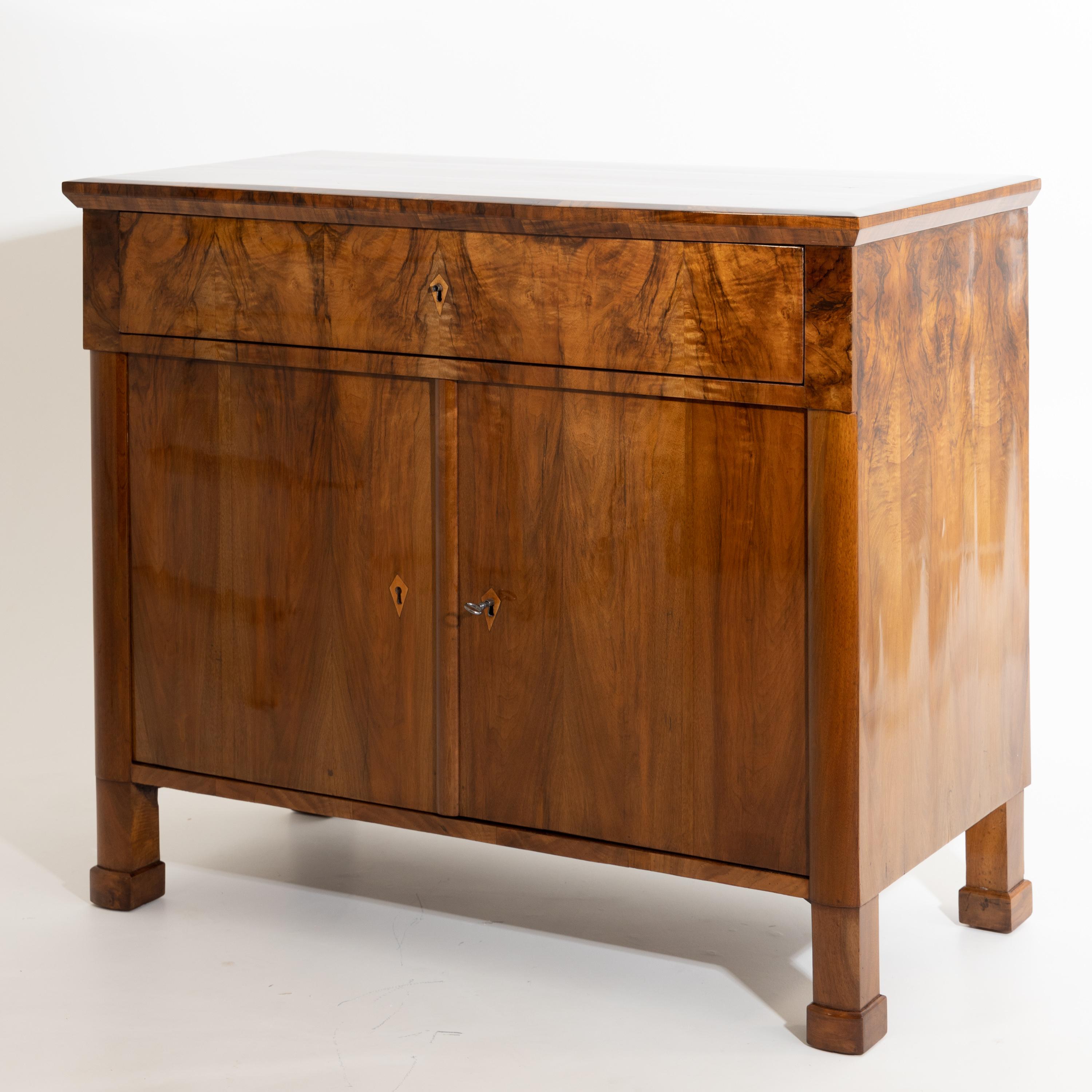 Half cupboard with wide top drawer and two doors, standing on plinthed square feet. Very beautiful walnut veneer. The sideboard has been expertly hand polished.