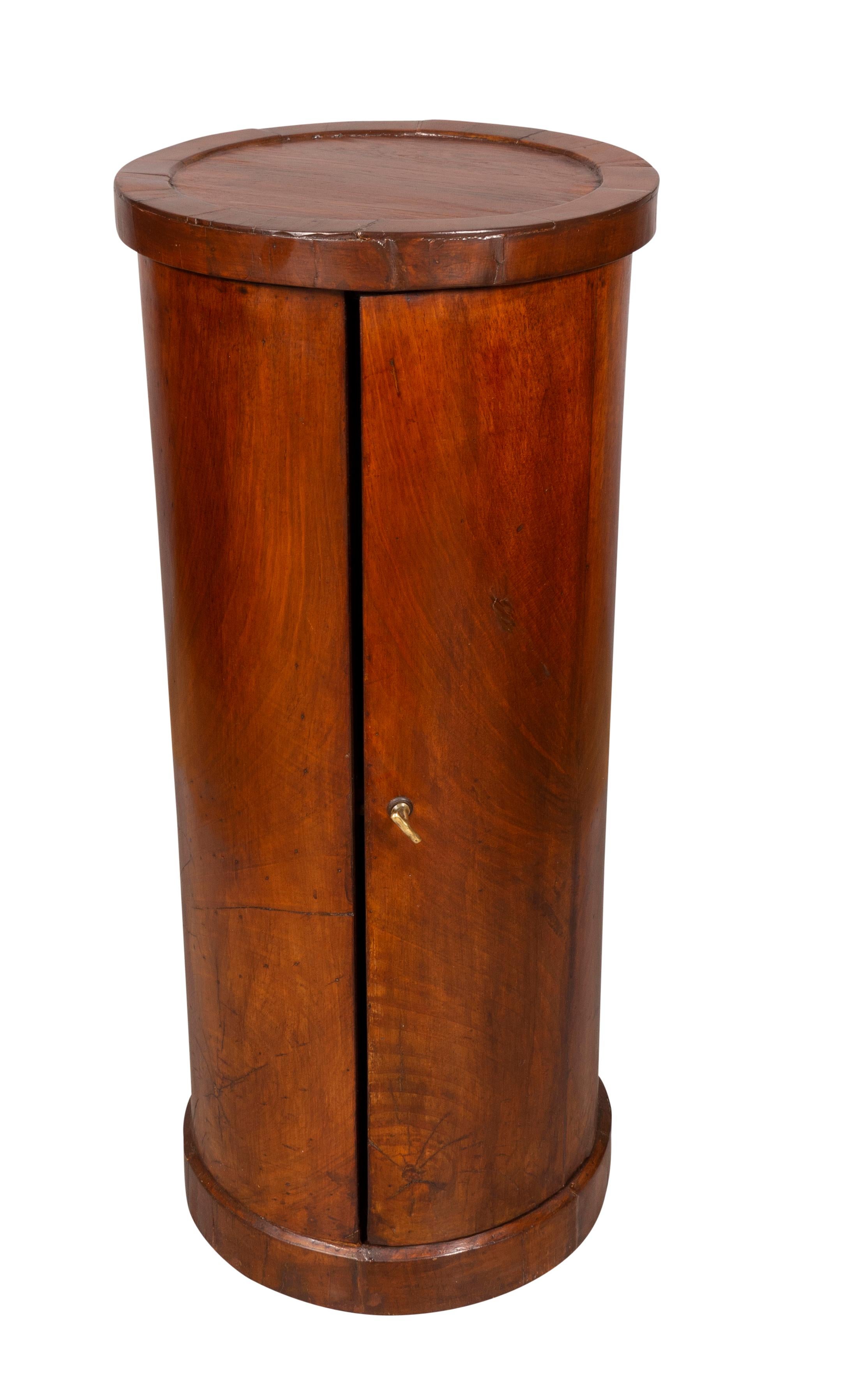 Cylindrical with a cabinet door with brass handle.