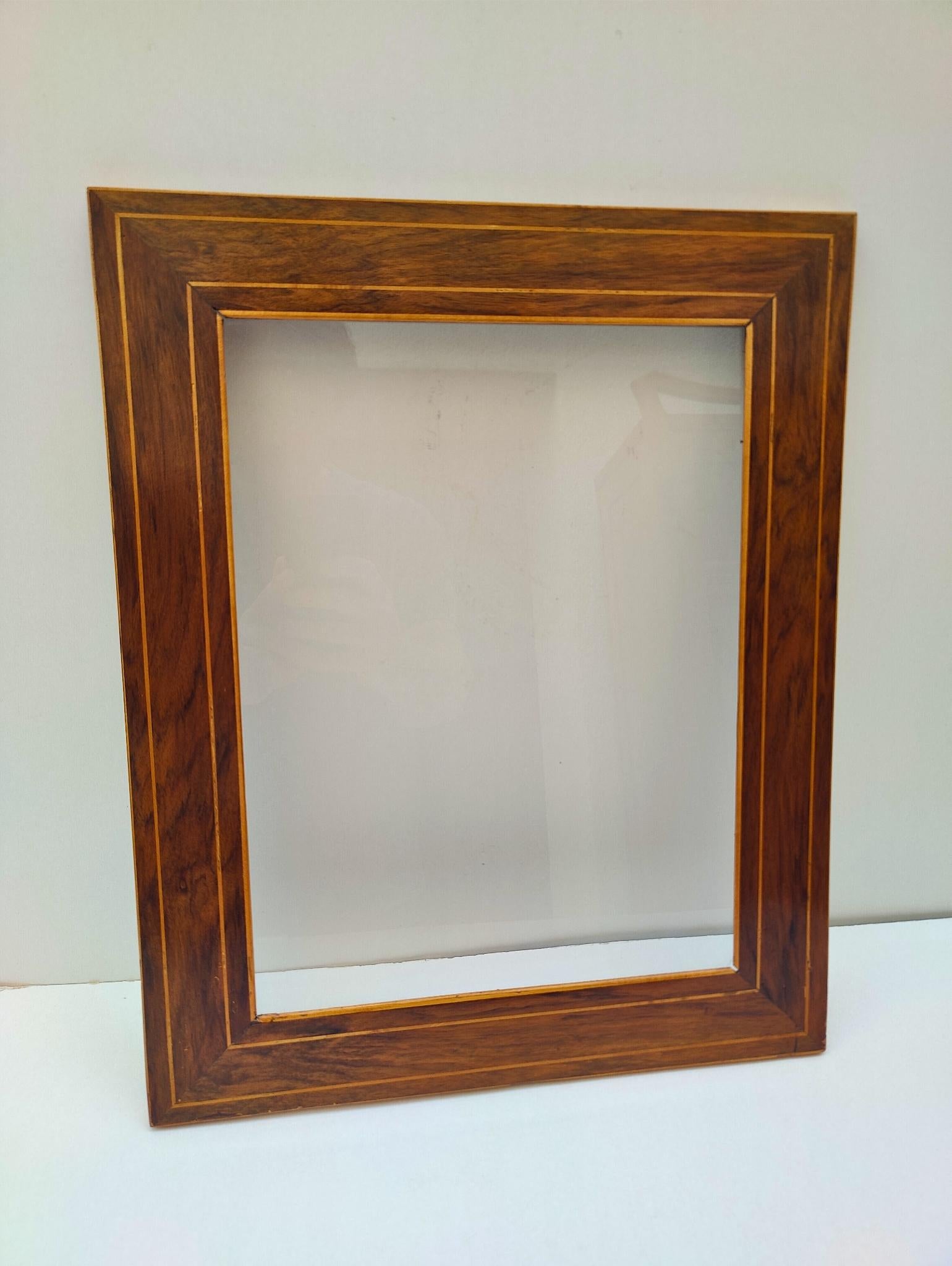 This refined Biedermeier picture frame dates from around 1830 and showcases the timeless elegance of the era. Crafted from richly grained walnut veneer on softwood, the frame is adorned with a fine lindenwood string inlay that highlights the clean