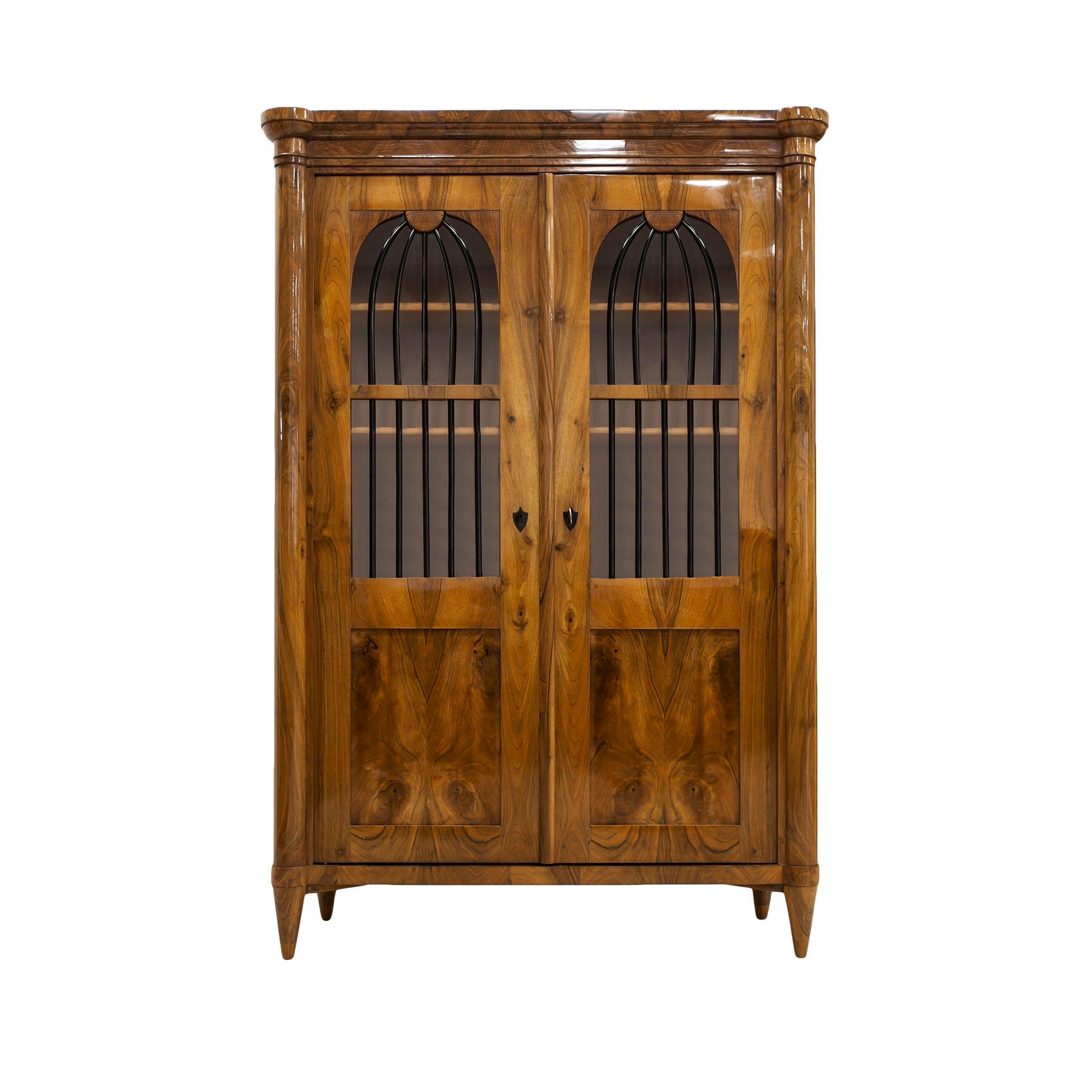 This Biedermeier vitrine comes from Germany from the first half of 19th century. The piece is made of coniferous wood, veneered with beautiful walnut veneer. It is after professional renovation and is in very good condition. It features beautifully