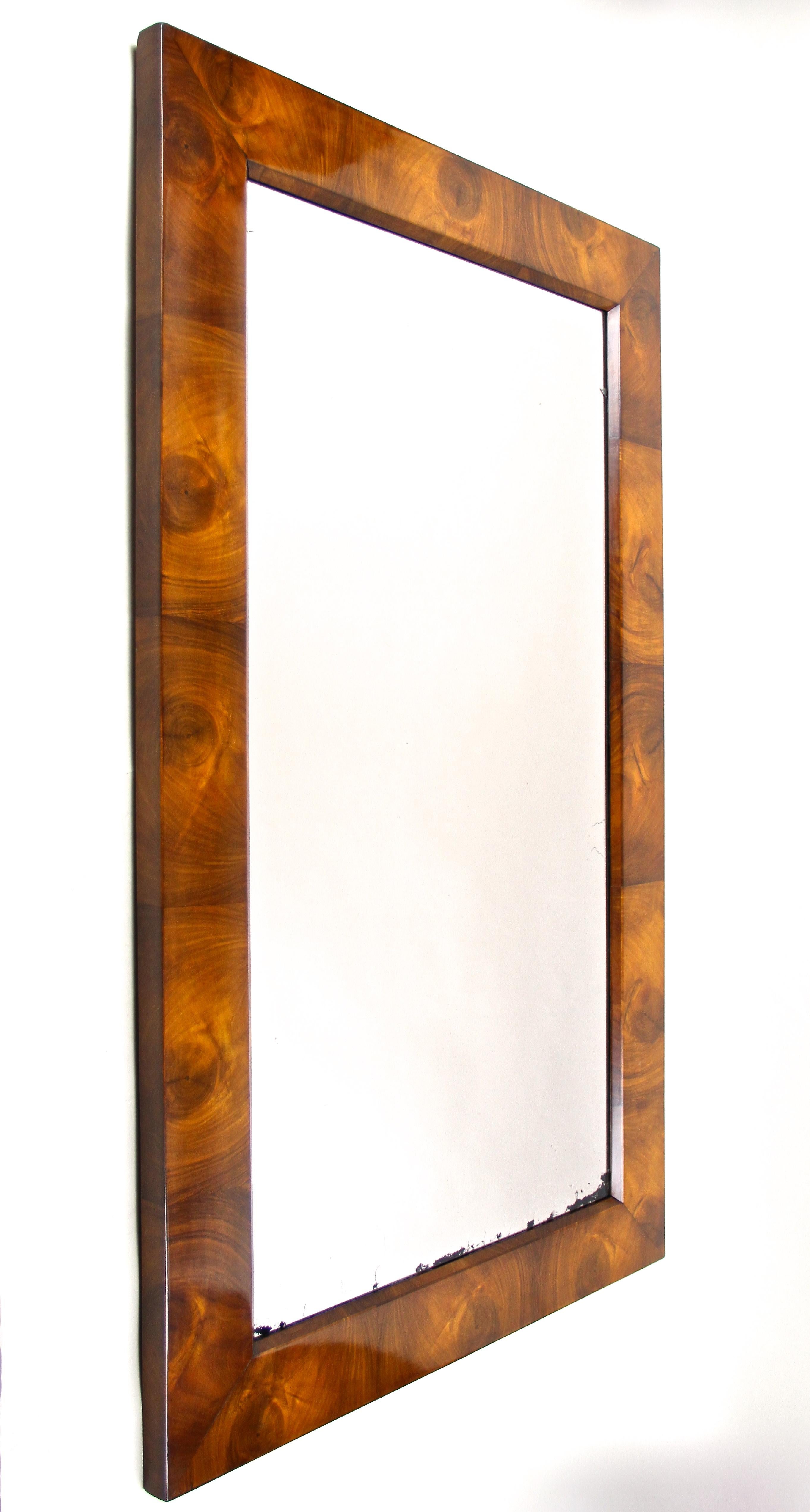 Striking Biedermeier wall mirror from the early 19th century in Vienna/ Austria around 1820. This magnificent wall mirror from the very early renown Biedermeier period comes with a traditional overlapped substructure made of spruce wood and