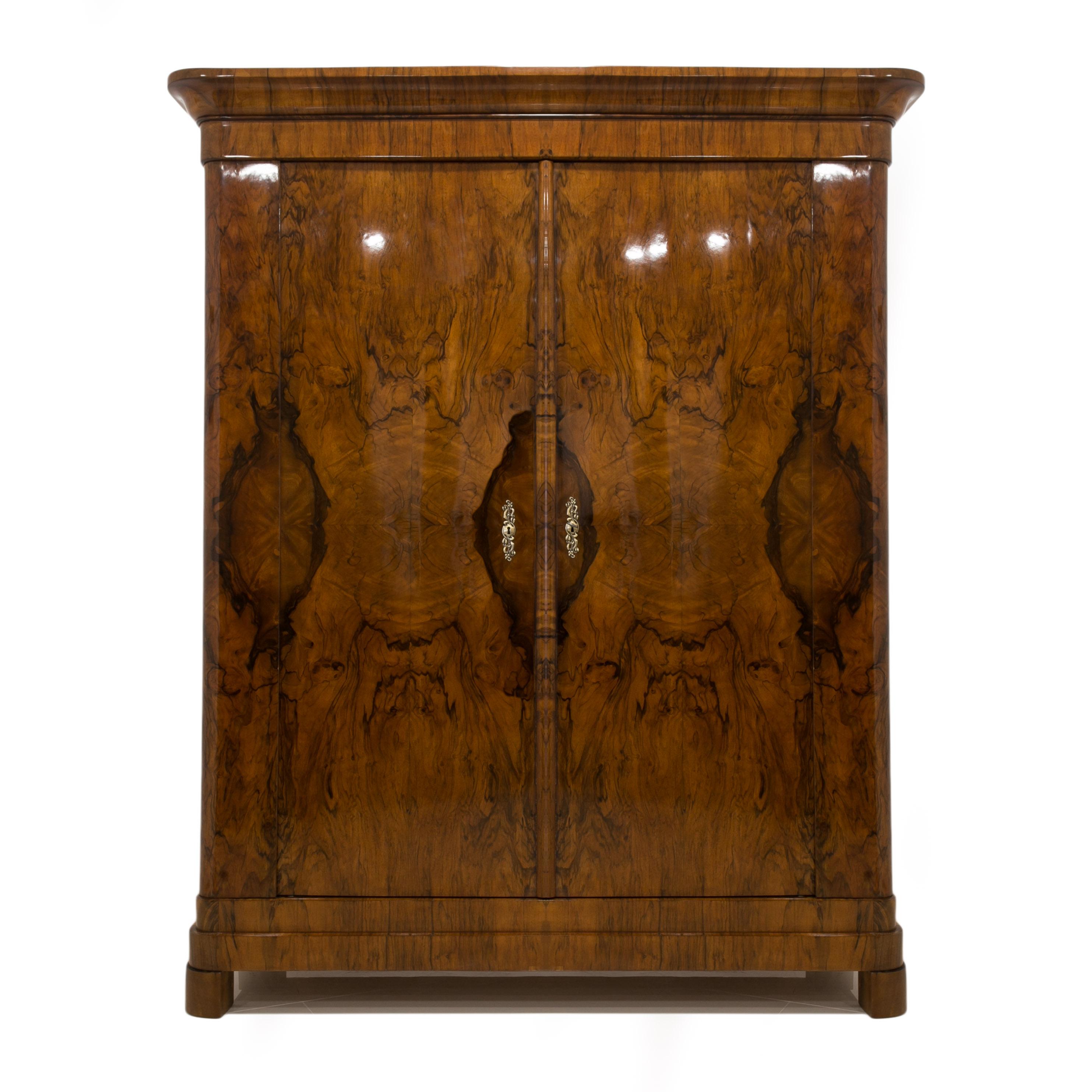 Beautiful, original Biedermeier wardrobe made of softwood veneered with walnut. The piece comes from Germany from 19th century. A unique technique of veneering was used here - one veneer leaf from top to bottom, starting from the cornice, through