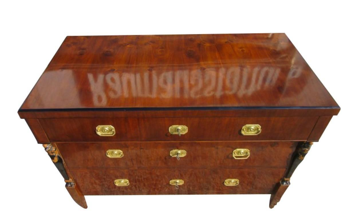 A Biedermeier commode veneered with walnut wood. 1830 manufactured piece consists of a corpus which is made of softwood and veneered with walnut wood. The wonderful dark brown color of the veneer fits perfectly to the brass fittings. Three large