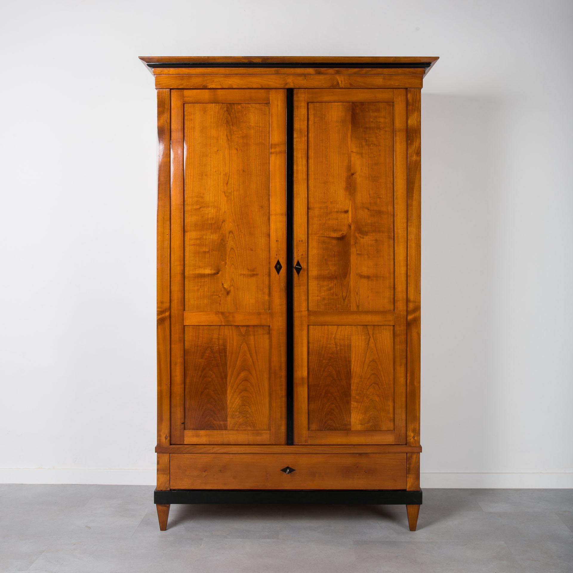 This Biedermeier wardrobe was made in Germany in 19th century. It is made of solid cherry wood. The piece is after complete renovation. Surface was cleaned and refinished with shellac polish, applied by hand with a tampon, which, in addition to an