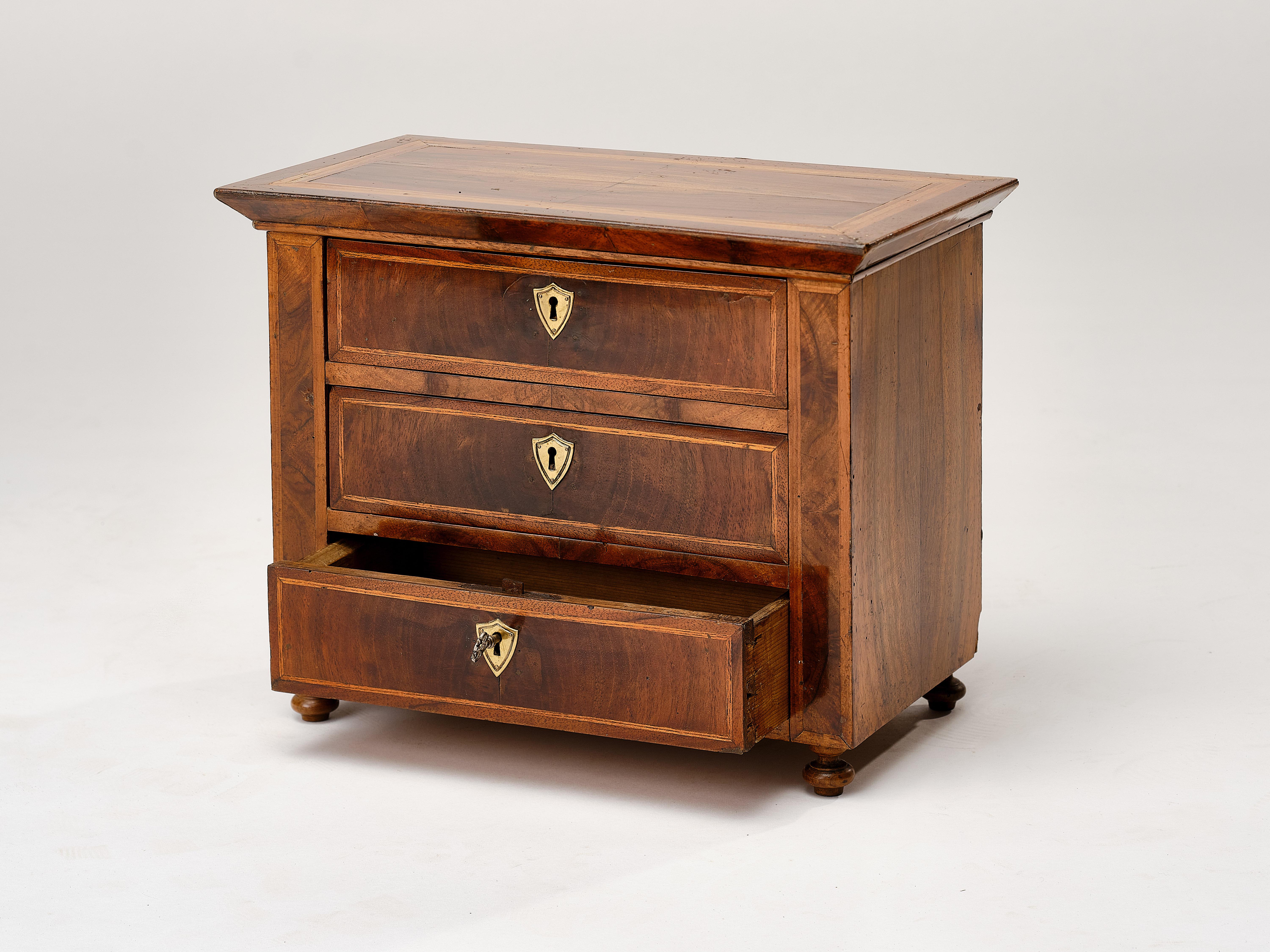 An original small model chest of drawers from the Biedermeier period with 3 lockable drawers and original key!
The body is made of softwood and veneered with walnut and other wood. Germany made 1840
Measurement:
The top shelf of the chest of drawers