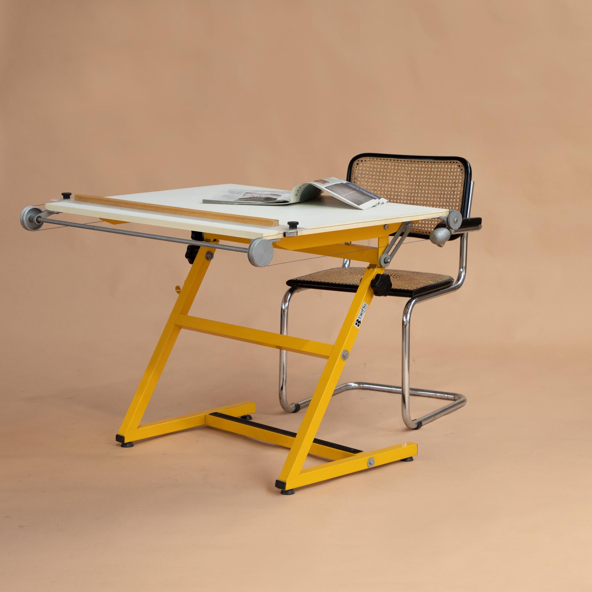 Versatile architects drafting table come desk manufactured by biefflplast. 
This is in great condition. Vibrant yellow coated metal frame makes a real statement. Manufacturers label is still visible. 
The white laminate drawing board can be