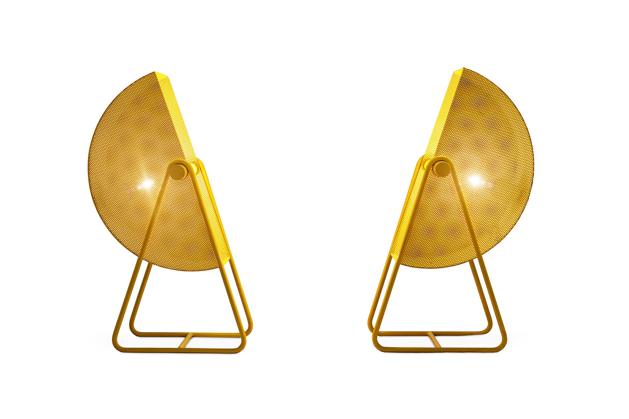 Adjustable table lights in yellow coated metal. The shades are perforated and create a nice light partition. The lamps have a very modern appearance due the sharp lines and geometrical shapes.

Measures: W 25, D 25, 40 H, 55 - 59 cm.