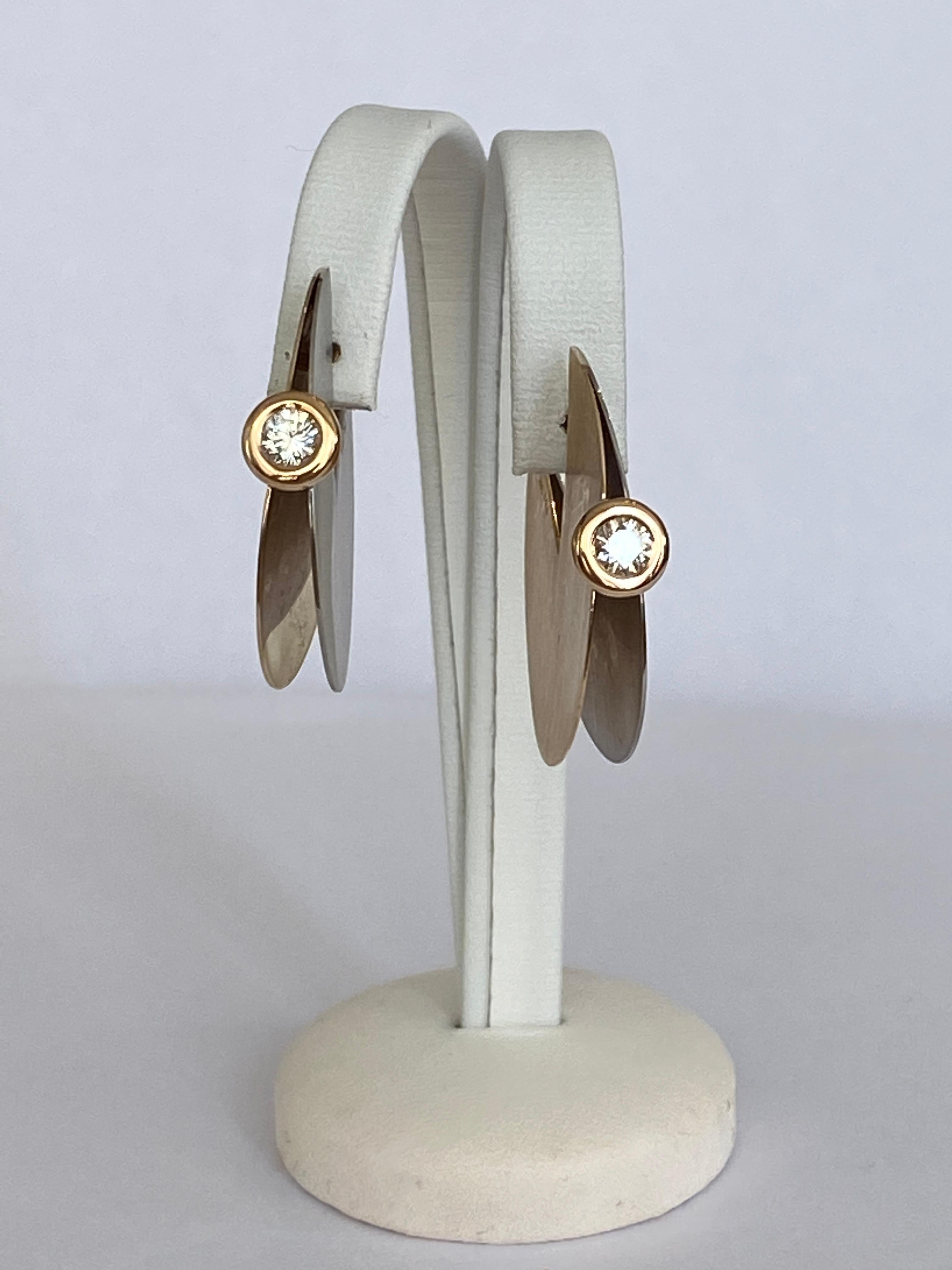 Offered beautiful in the form of two almost completely round discs, diverging discs between which a brilliant cut diamond with a total weight of approx. 0.50 ct., colour G-, clarity VVS. Unique piece made from 18 kt yellow gold and platina. Signed