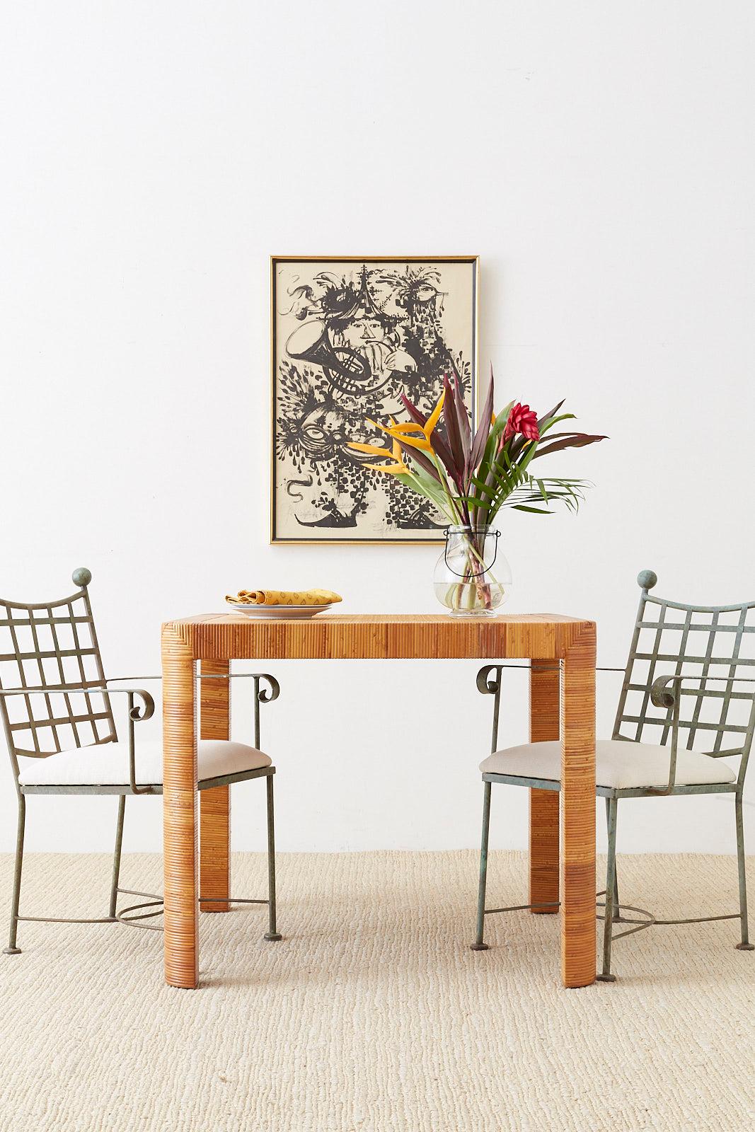 Chic bamboo and rattan breakfast or dining table featuring a basket weave frame and rounded legs. Produced by Bielecky Brothers in New York, makers of the best custom rattan furniture since nearly 1900. The tabletop is inset with a woven wicker for