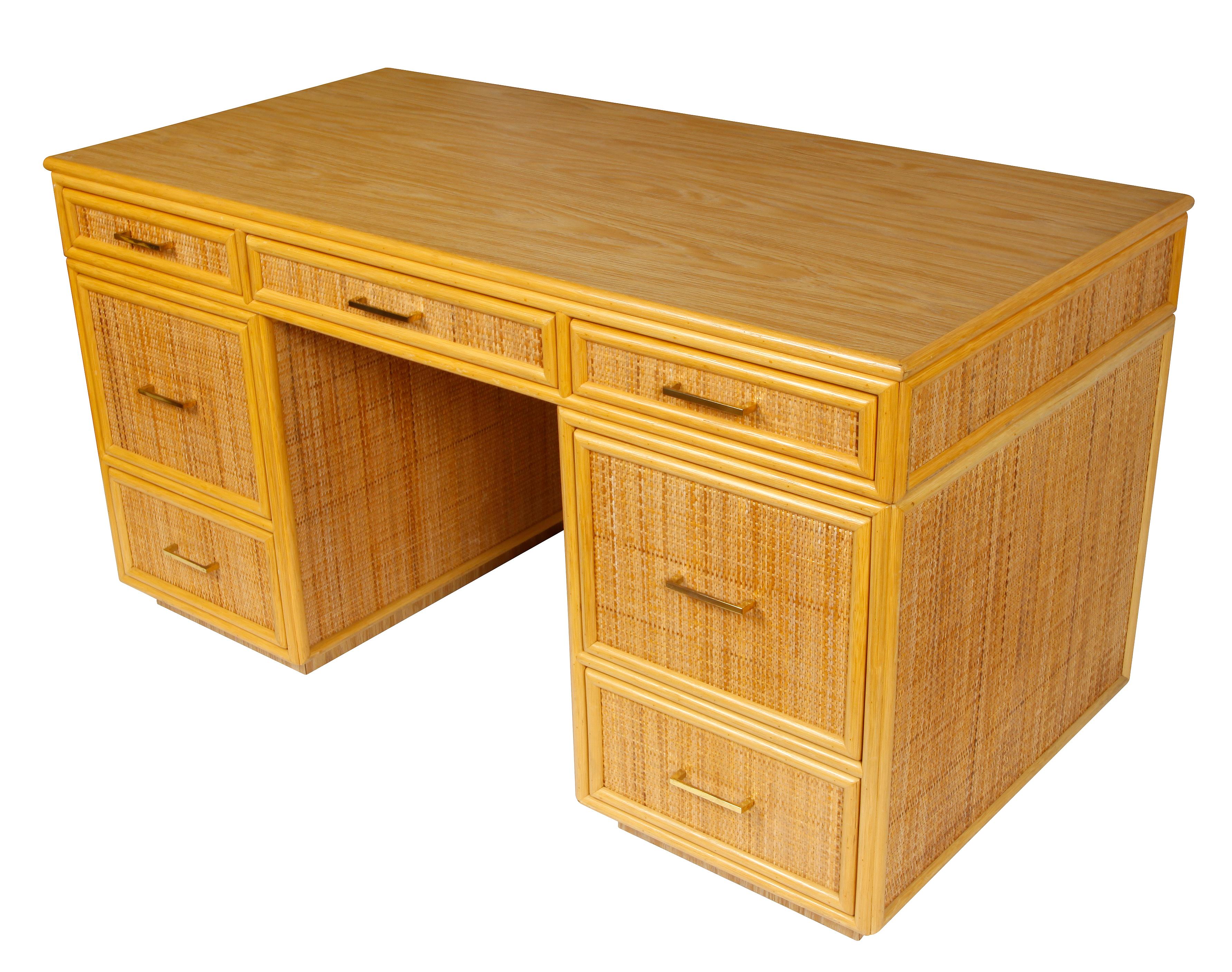 Bielecky rattan partner's desk with seven drawers. Brass drawer pulls and wood grain laminate top.