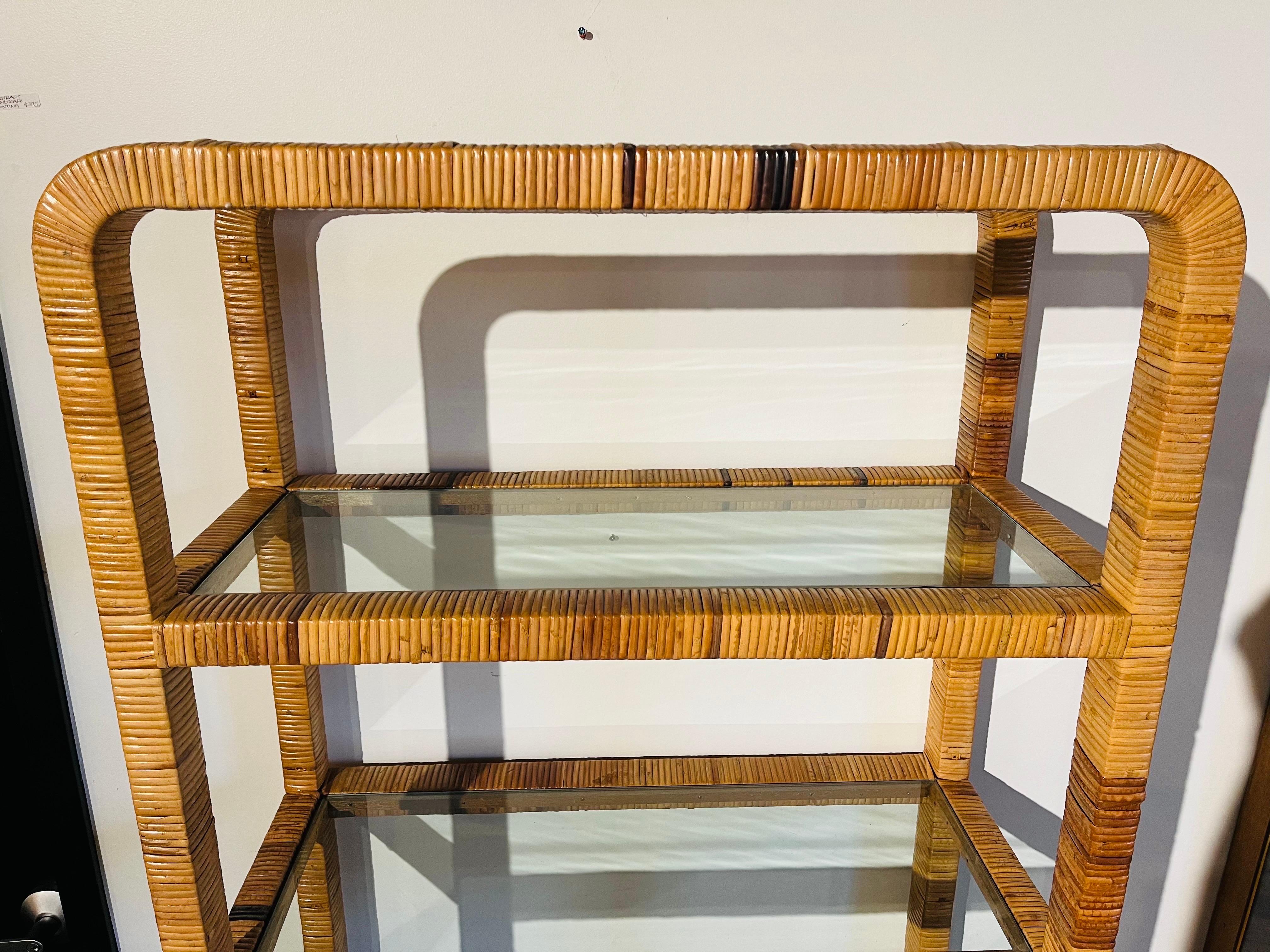 A vintage Bielecky Brothers style wrapped rattan four shelf etagere shelving unit. This piece features a wrapped framework design incorporating rounded corners at both the top and bottom of the etagere as well as on the front and back of the